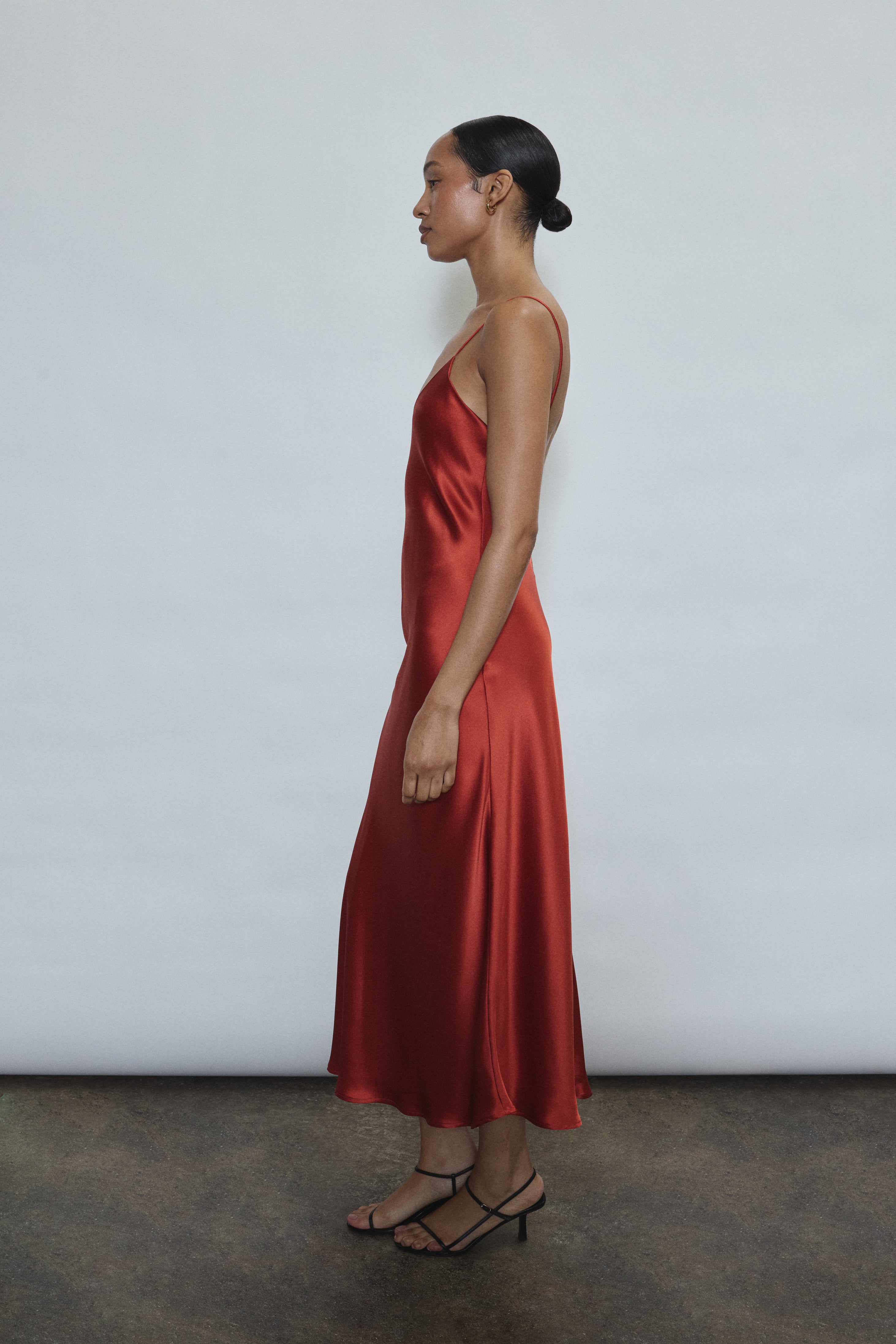 Side view of the rust sueded silk charmeuse Kamperett Caroline Midi Slip Dress, showing the bias-cut drape.
