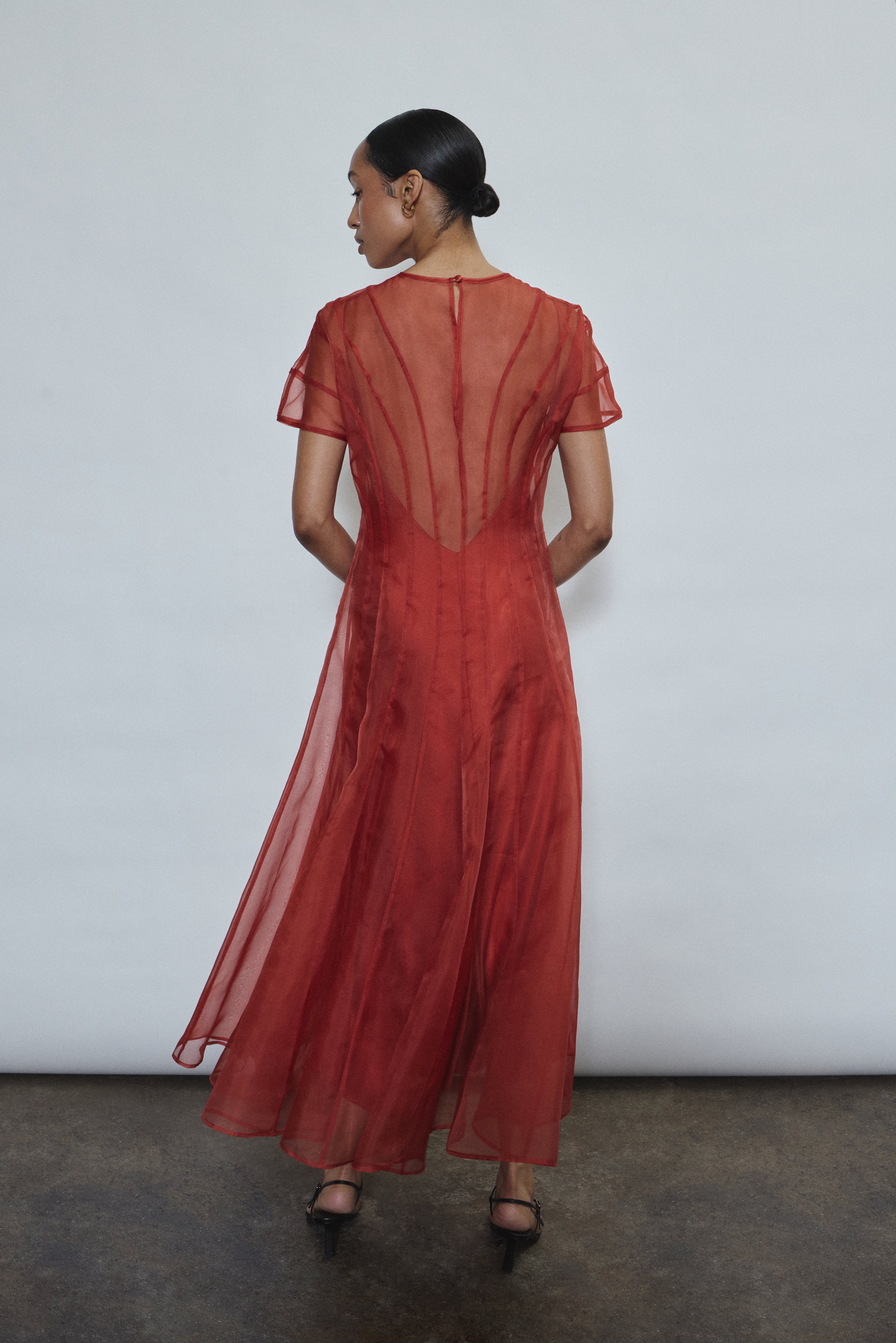 Back view of the rust Kamperett Caroline Midi Slip Dress styled with the Anemoia Midi silk organza overlay.