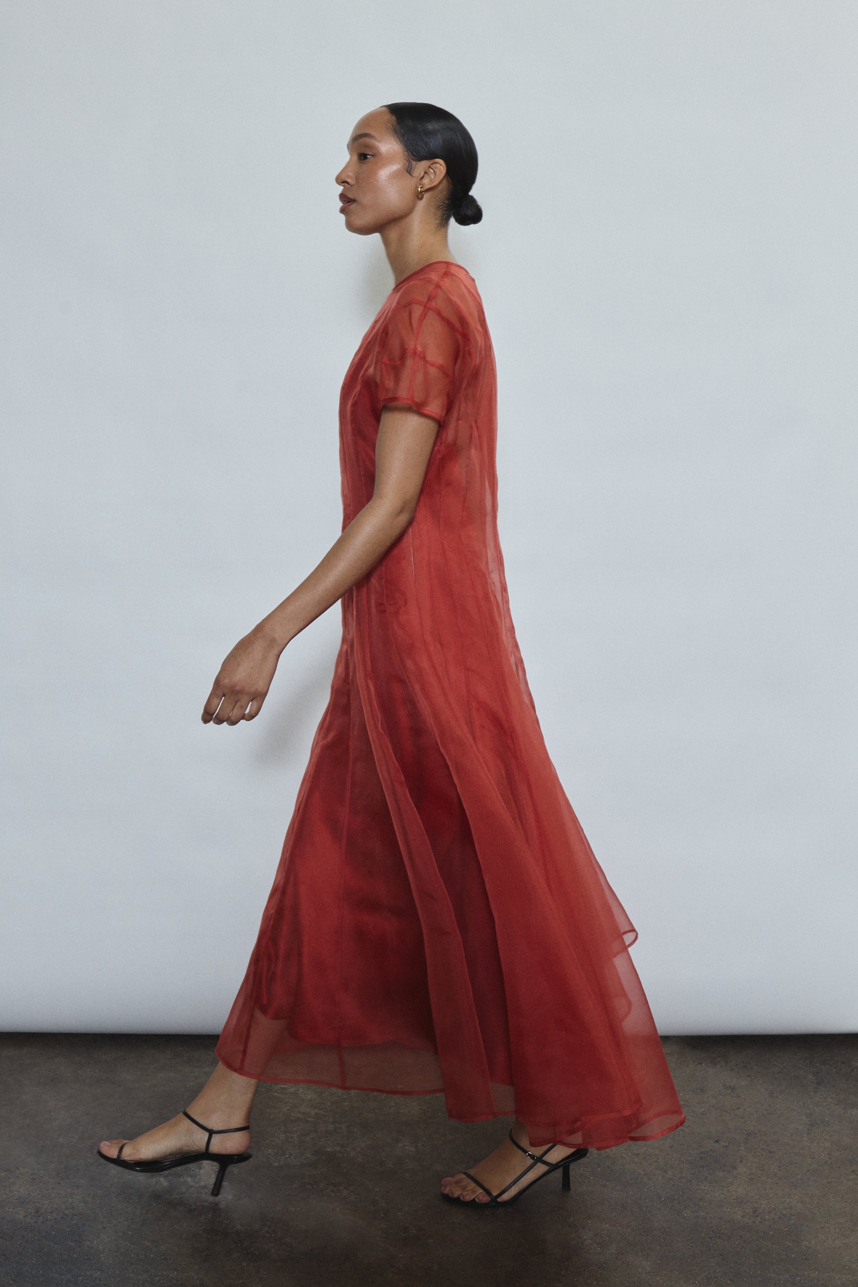 Side view of the rust Kamperett Caroline Midi Slip Dress paired with the Anemoia Midi in sheer silk organza.