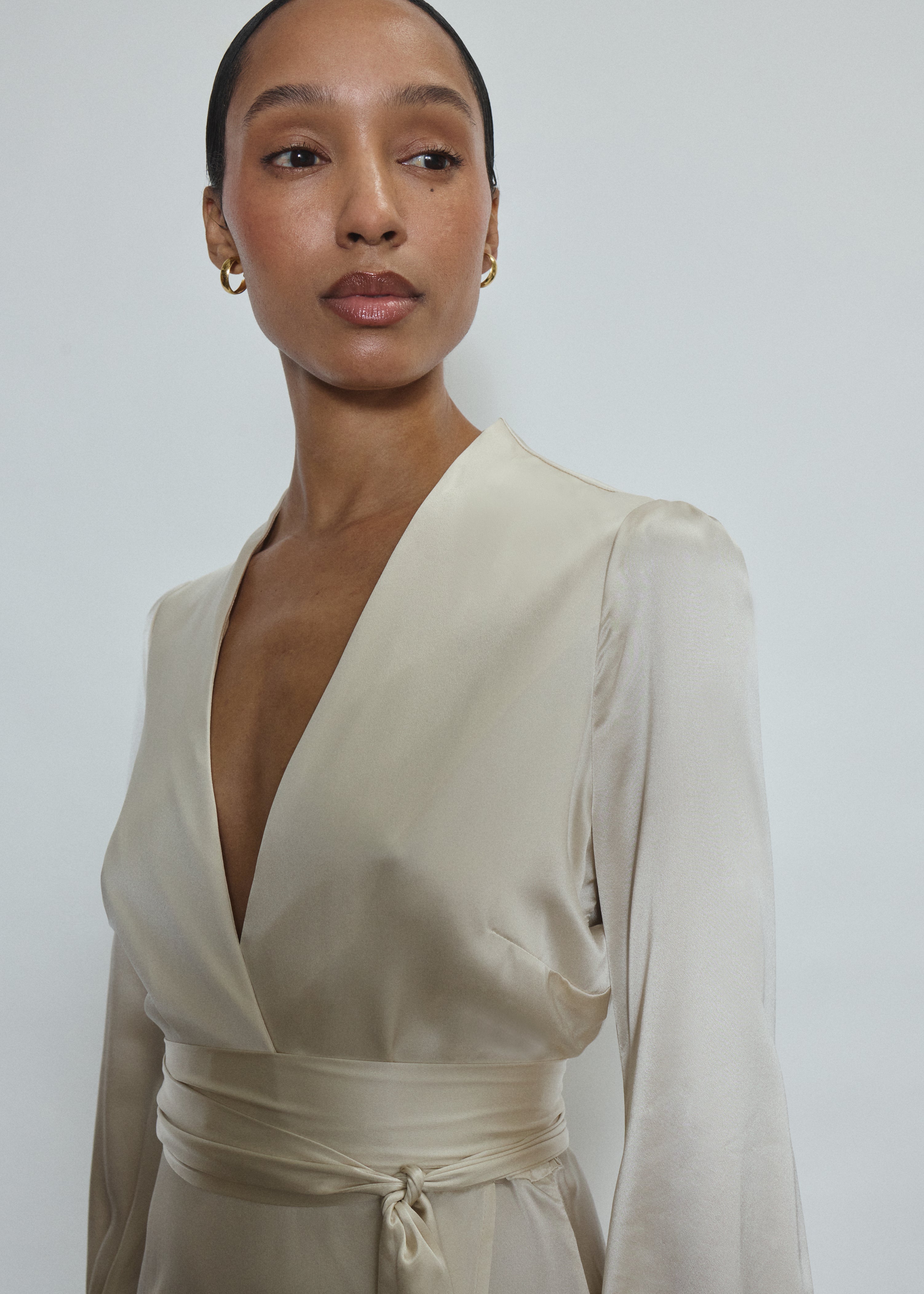 Bride wearing the ivory silk charmeuse Adelaide wrap gown, featuring a plunging neckline.