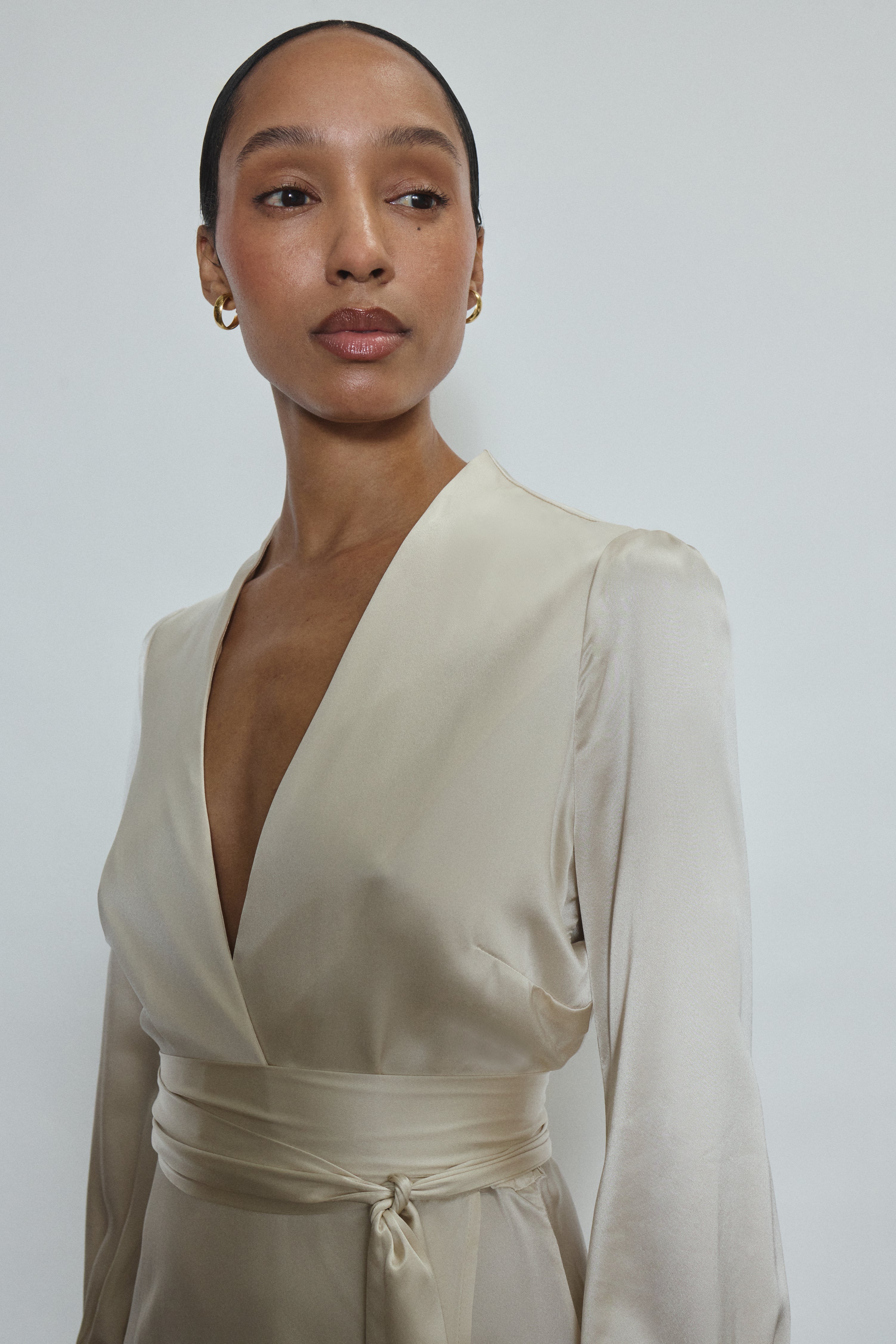 Bride wearing the ivory silk charmeuse Adelaide wrap gown, featuring a plunging neckline.