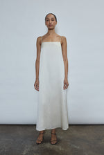 Front view of a bride wearing the ivory silk charmeuse Kamperett Agnes Slip Dress, a boxy midi slip with straight neckline and fixed corded straps.