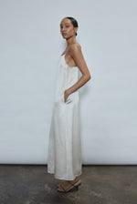 Side view of the ivory silk charmeuse Kamperett Agnes Slip Dress showing the loose midi silhouette and corded straps.