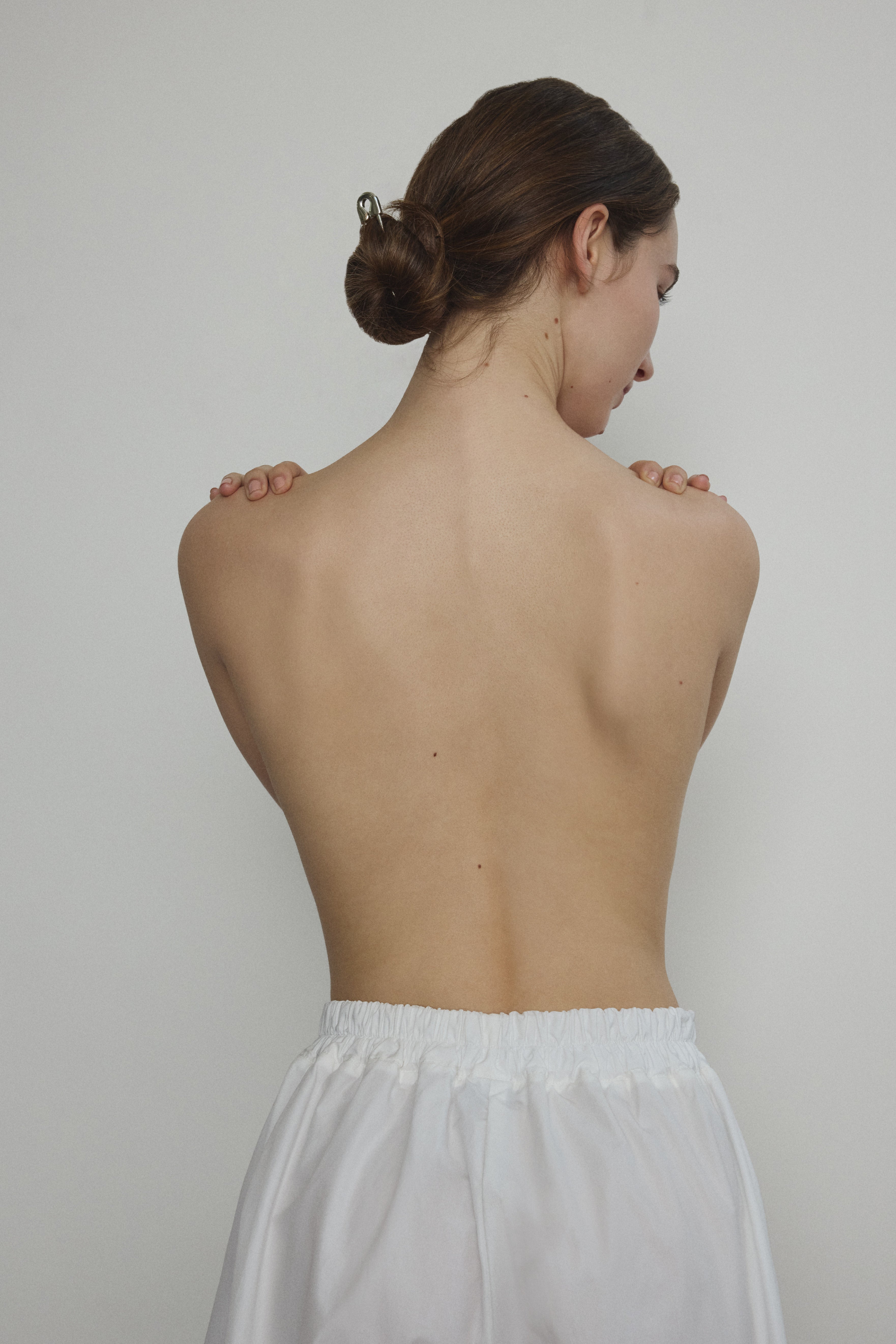 Model wearing the Kamperett Alix Pant in White, featuring a high-waisted wide-leg silhouette in crisp Japanese cotton lawn with deep side pockets.