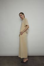 Model wearing the Kamperett Alix Pant in Beige silk crepe, featuring a high-waisted wide-leg fit and a sophisticated fluid drape.