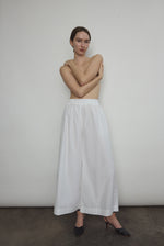 Model wearing the Kamperett Alix Pant in White, featuring a high-waisted wide-leg silhouette in crisp Japanese cotton lawn with deep side pockets.