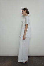 Model wearing the Kamperett Alix Pant in White, featuring a high-waisted wide-leg silhouette in crisp Japanese cotton lawn with deep side pockets.