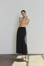 Front view of a model wearing the black silk crepe Kamperett Alix Silk Crepe Pant, a wide-leg pull-on pant with elastic waistband.