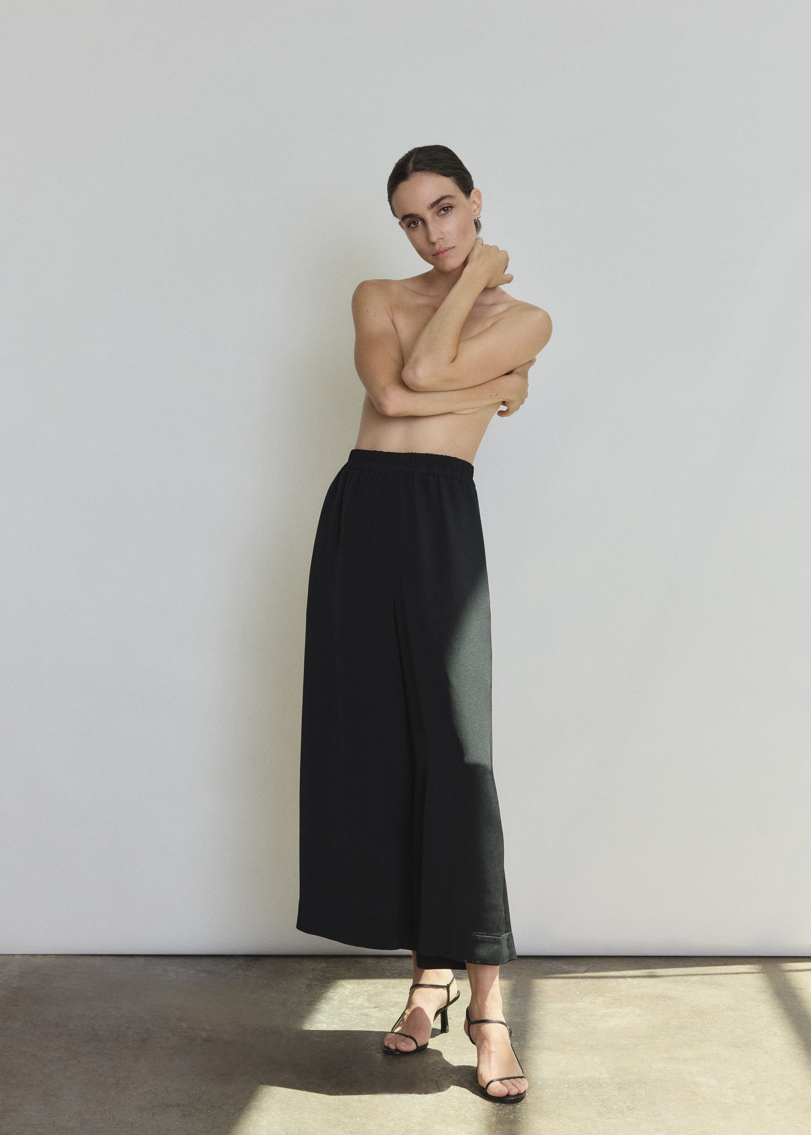 Front view of a model wearing the black silk crepe Kamperett Alix Silk Crepe Pant, a wide-leg pull-on pant with elastic waistband.