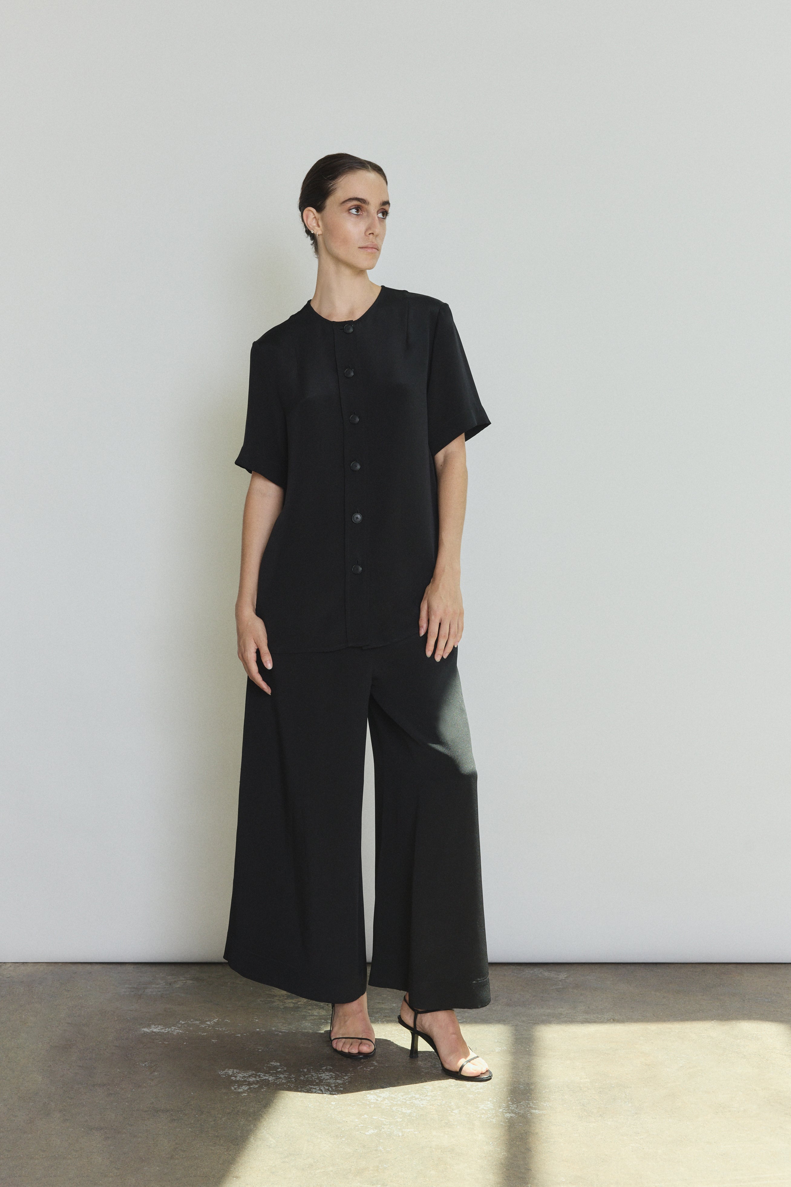 Model wearing the black Kamperett Alix Silk Crepe Pant styled with the Jette Silk Crepe Tee in Black.