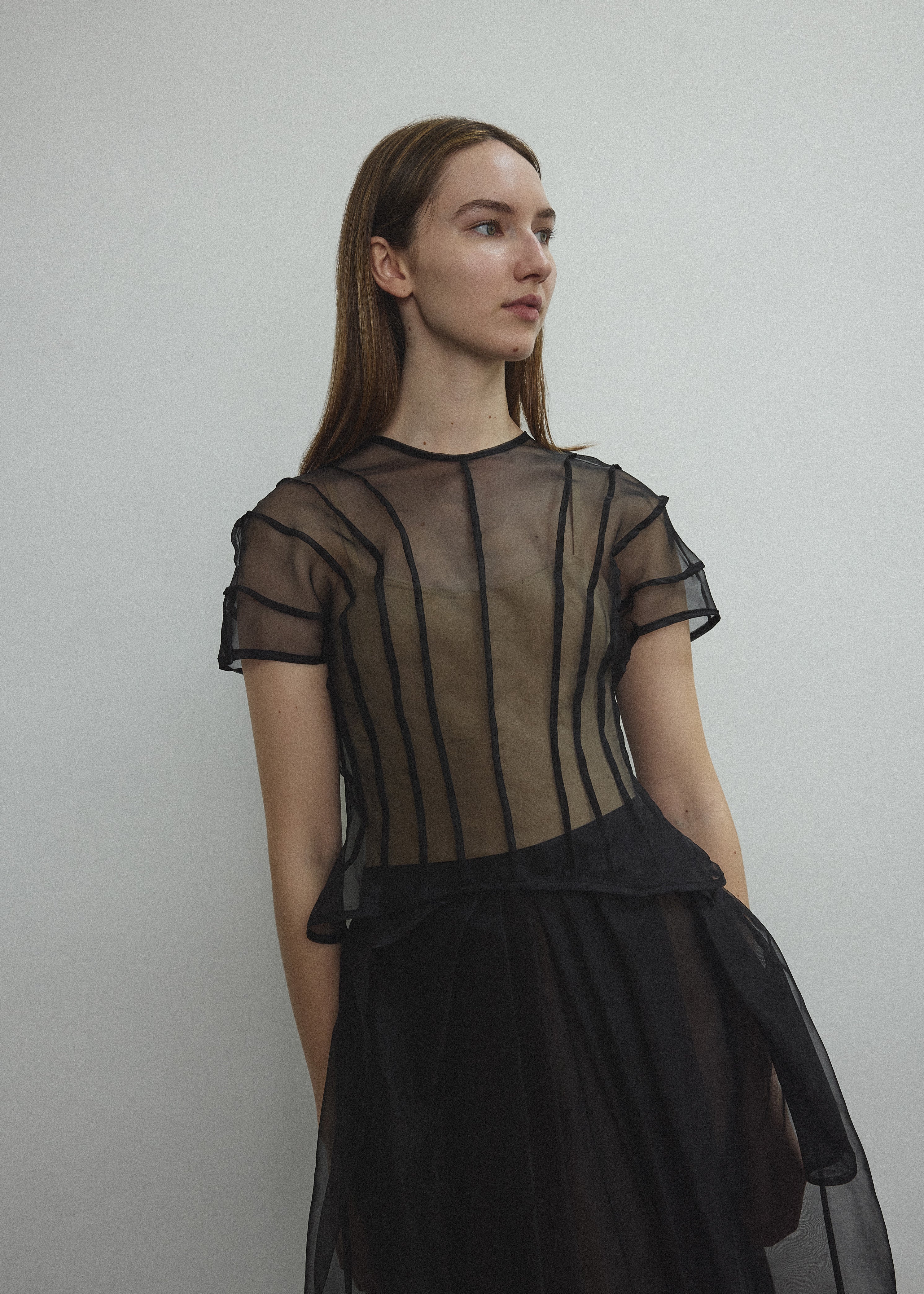 Model wearing the Kamperett Anemoia Blouse in Black silk organza, highlighting the voluminous sculptural sleeves and elegant mock neck silhouette.