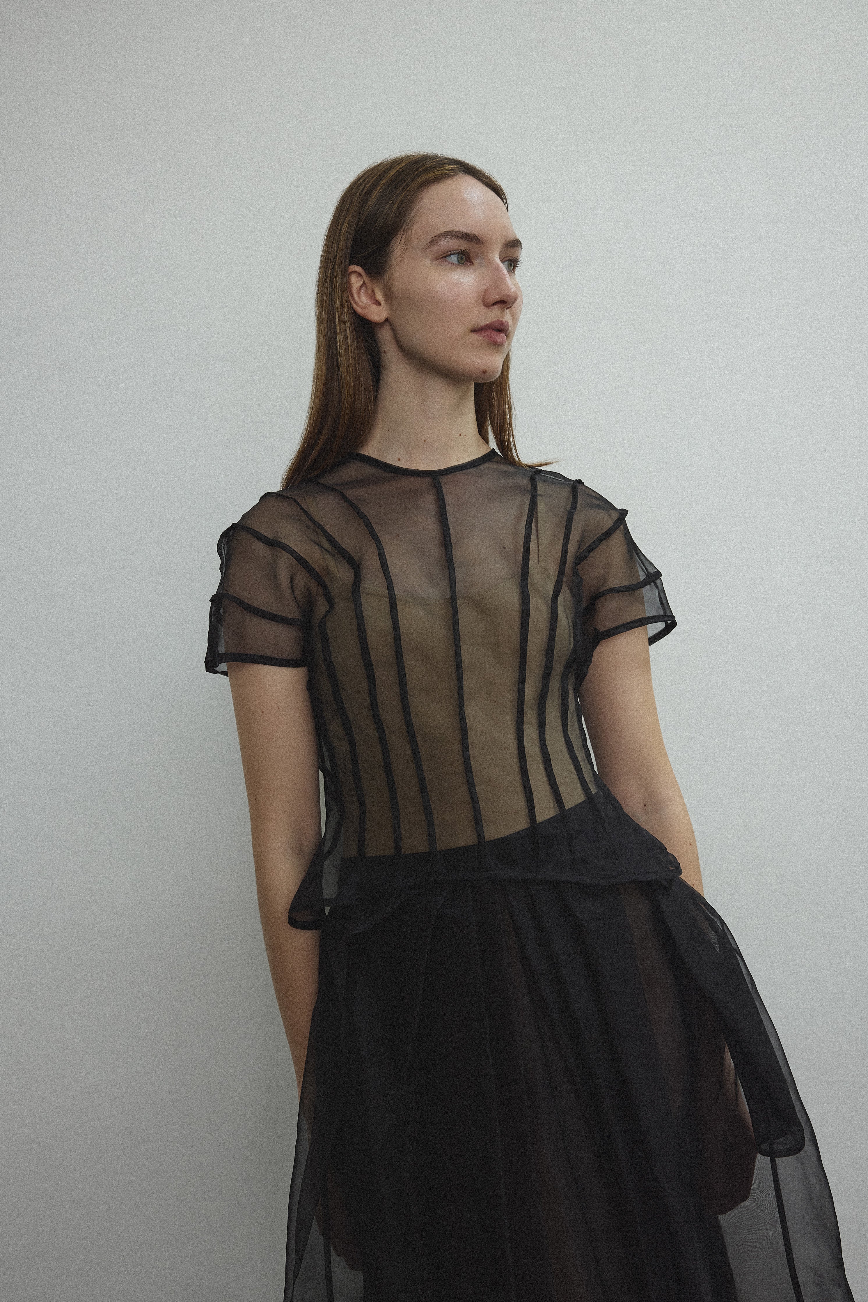 Model wearing the Kamperett Anemoia Blouse in Black silk organza, highlighting the voluminous sculptural sleeves and elegant mock neck silhouette.