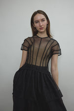 Model wearing the Kamperett Anemoia Blouse in Black silk organza, highlighting the voluminous sculptural sleeves and elegant mock neck silhouette.