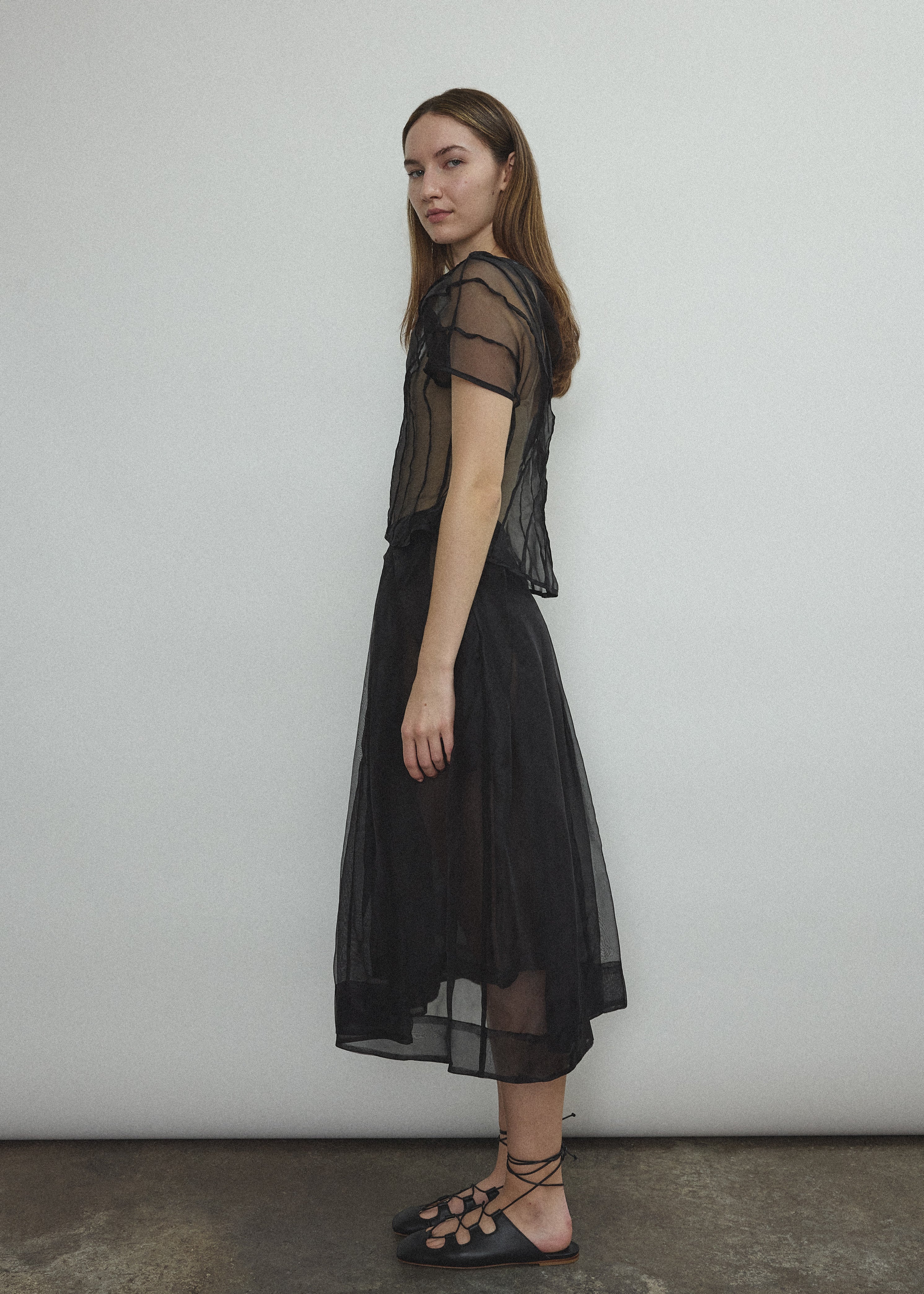Model wearing the Kamperett Anemoia Blouse in Black silk organza, highlighting the voluminous sculptural sleeves and elegant mock neck silhouette.