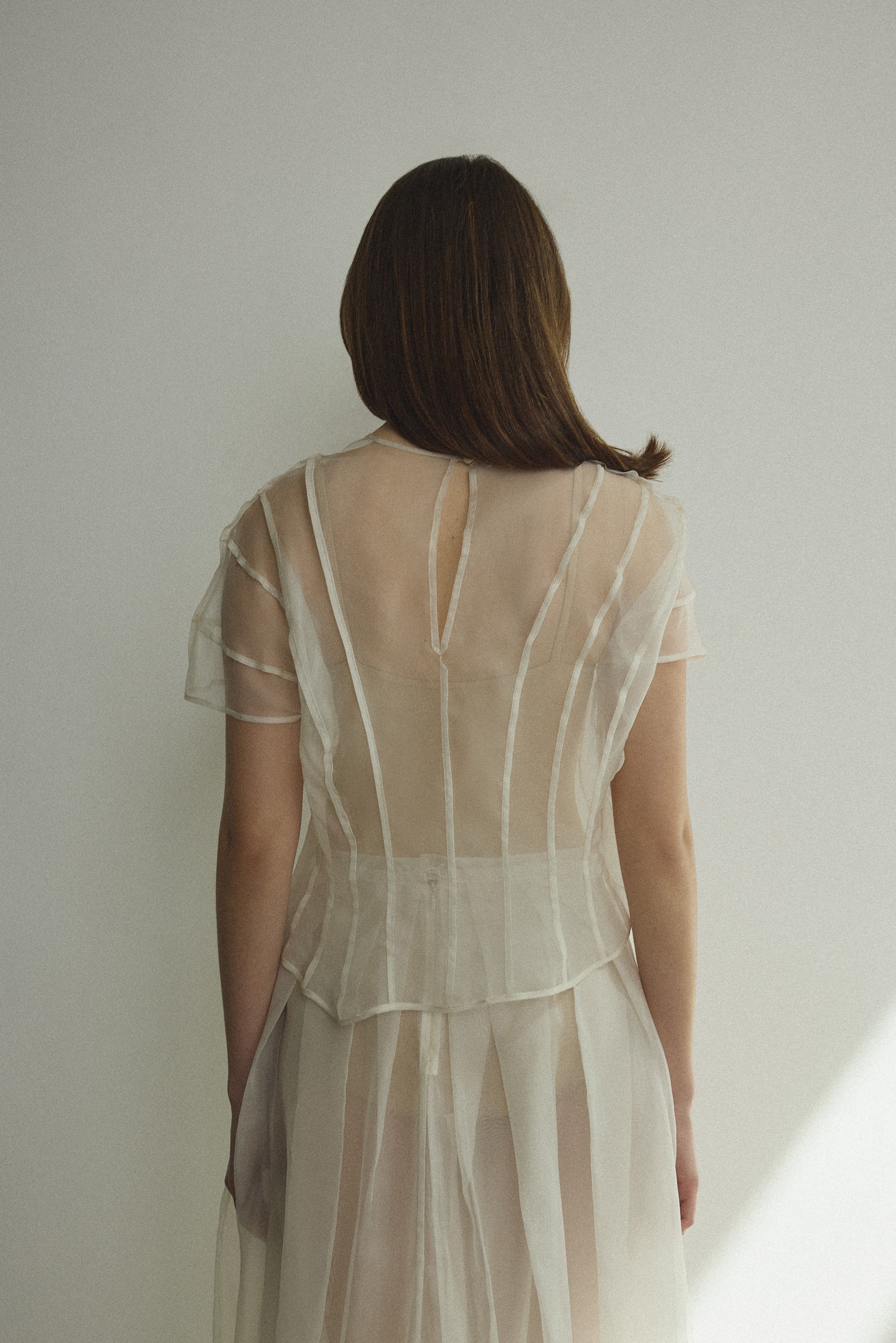 Model wearing the Kamperett Anemoia Blouse in Ivory silk organza, highlighting the voluminous sculptural sleeves and elegant mock neck silhouette.
