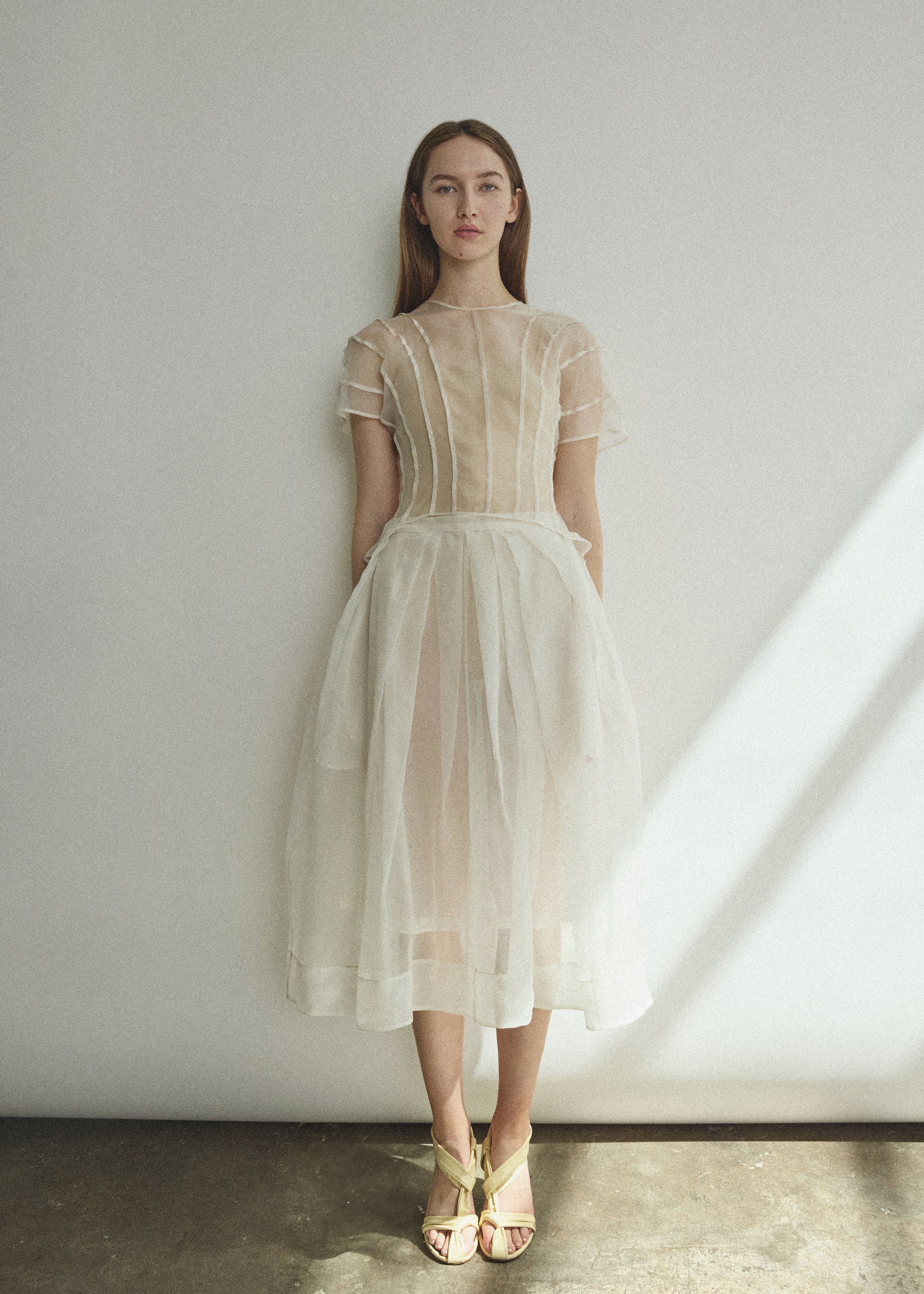 Model wearing the Kamperett Anemoia Blouse in Ivory silk organza, highlighting the voluminous sculptural sleeves and elegant mock neck silhouette.