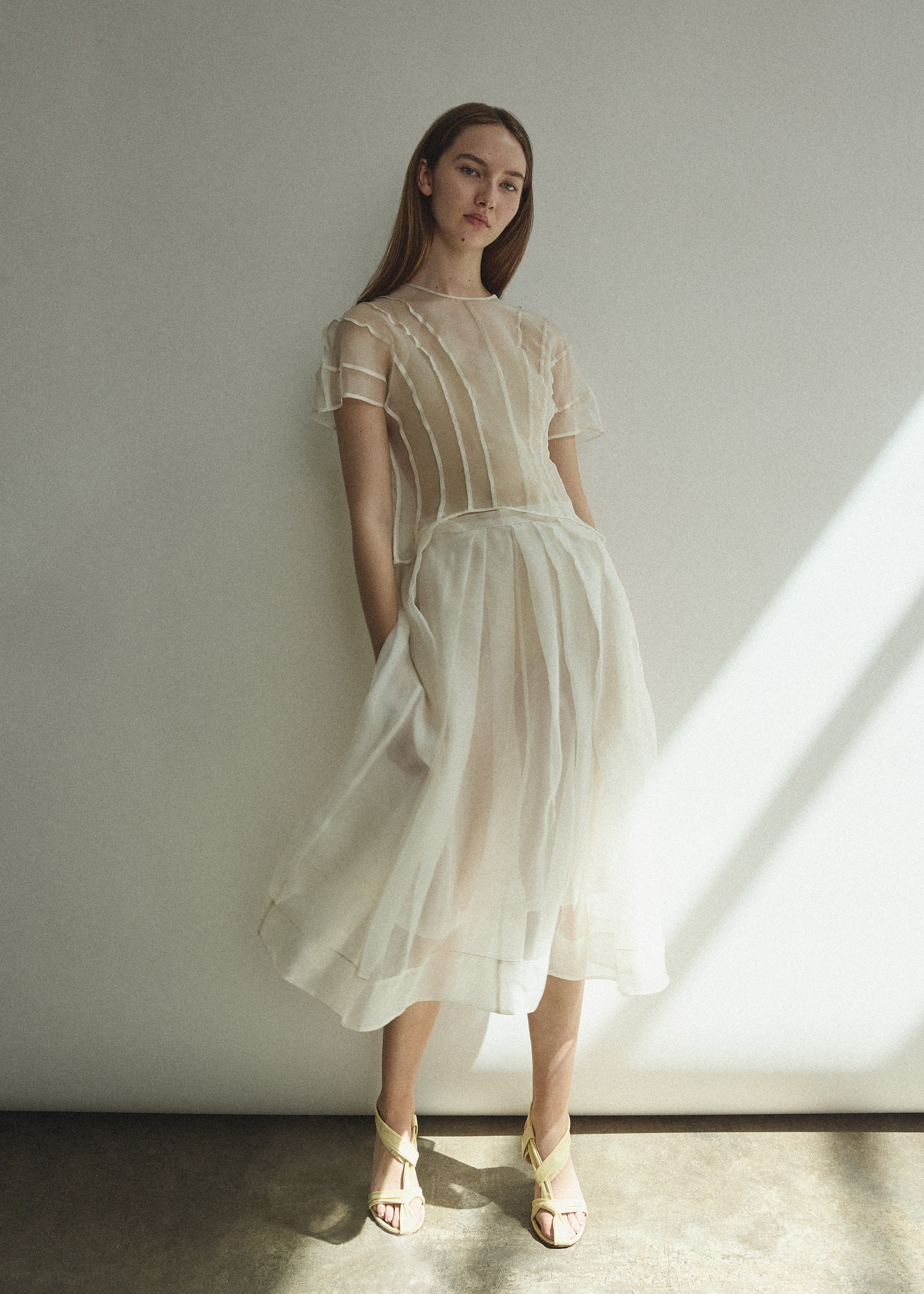 Model wearing the Kamperett Anemoia Blouse in Ivory silk organza, highlighting the voluminous sculptural sleeves and elegant mock neck silhouette.