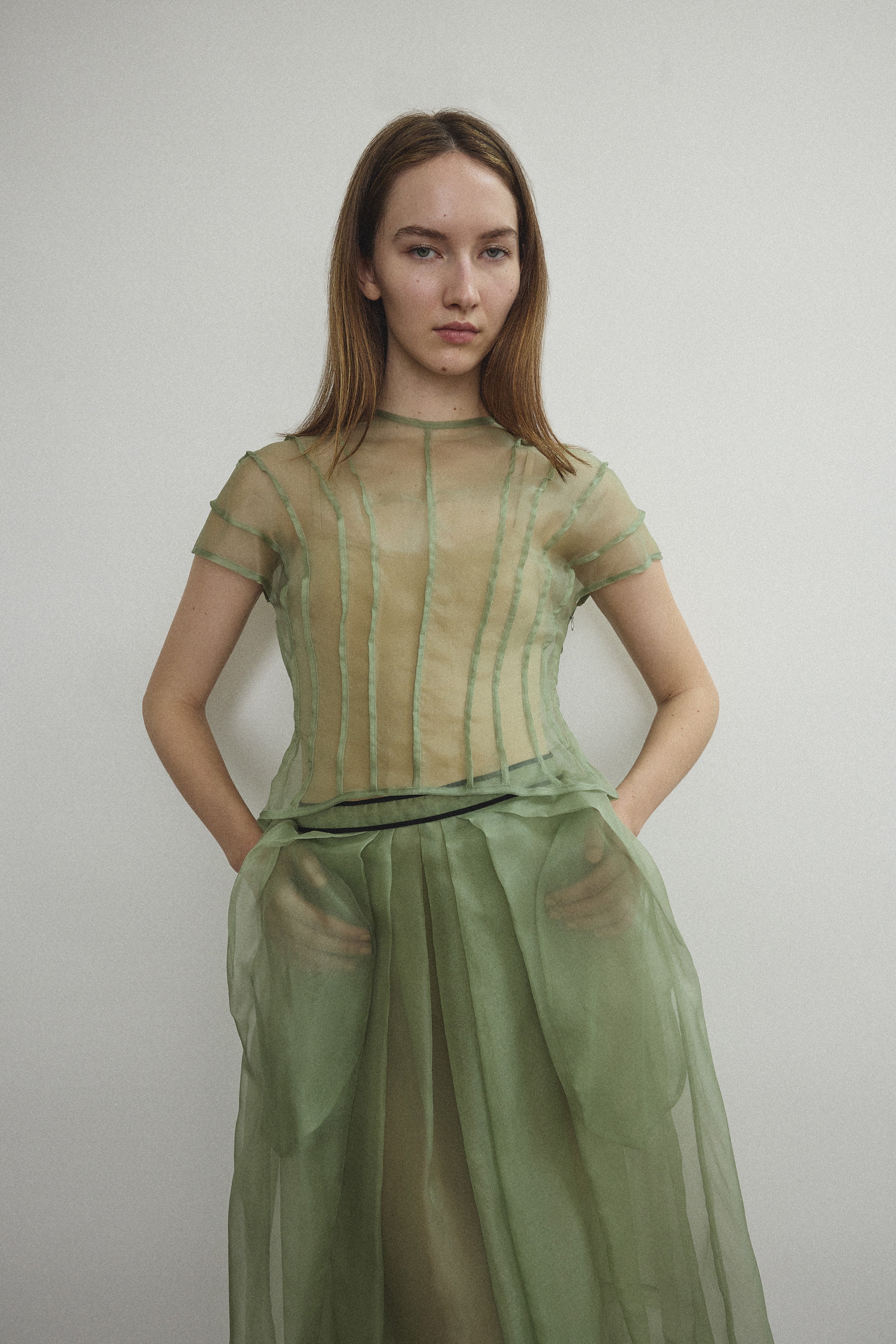 Model wearing the Kamperett Anemoia Blouse in Jade silk organza, highlighting the voluminous sculptural sleeves and elegant mock neck silhouette.