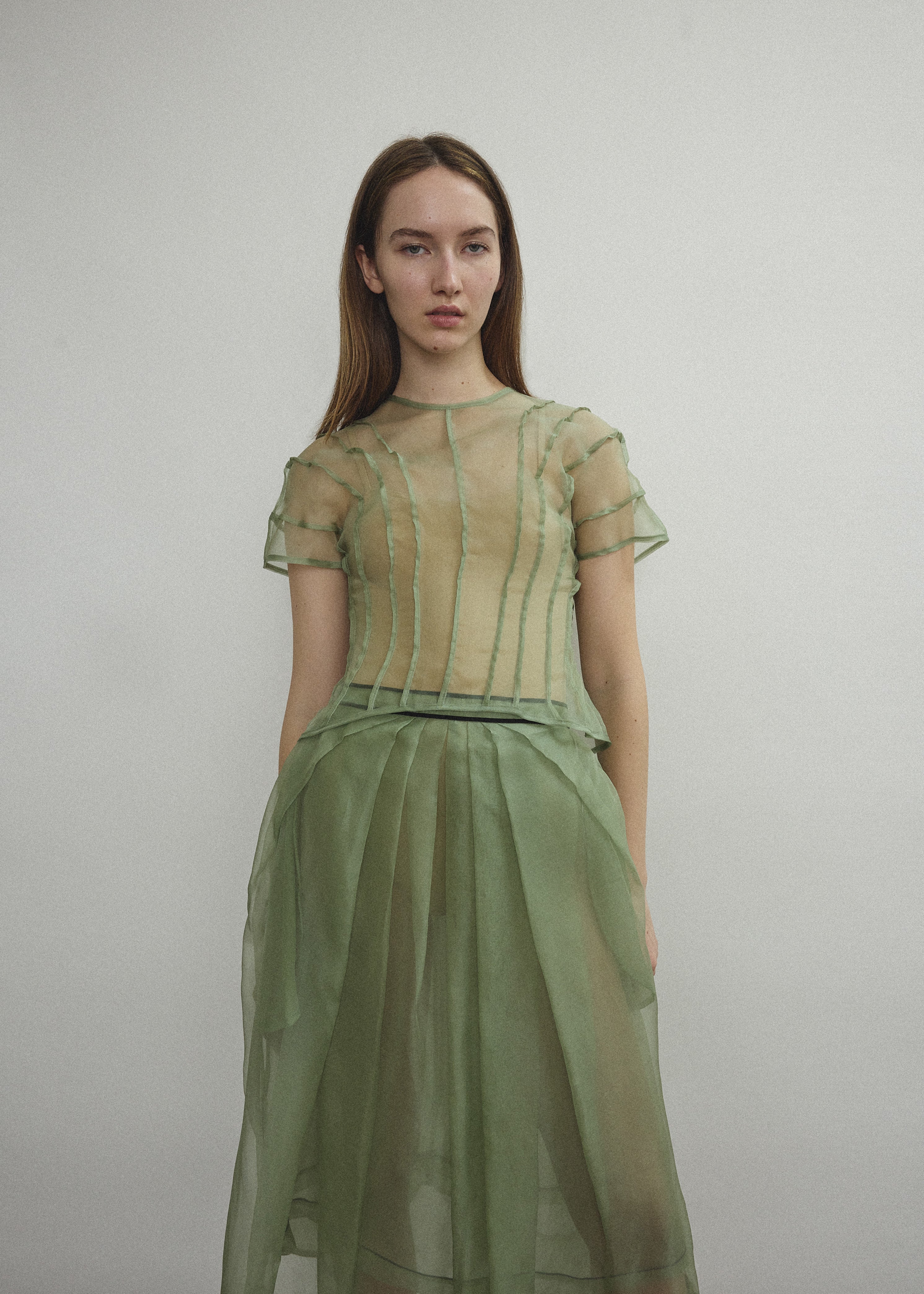 Model wearing the Kamperett Anemoia Blouse in Jade silk organza, highlighting the voluminous sculptural sleeves and elegant mock neck silhouette.