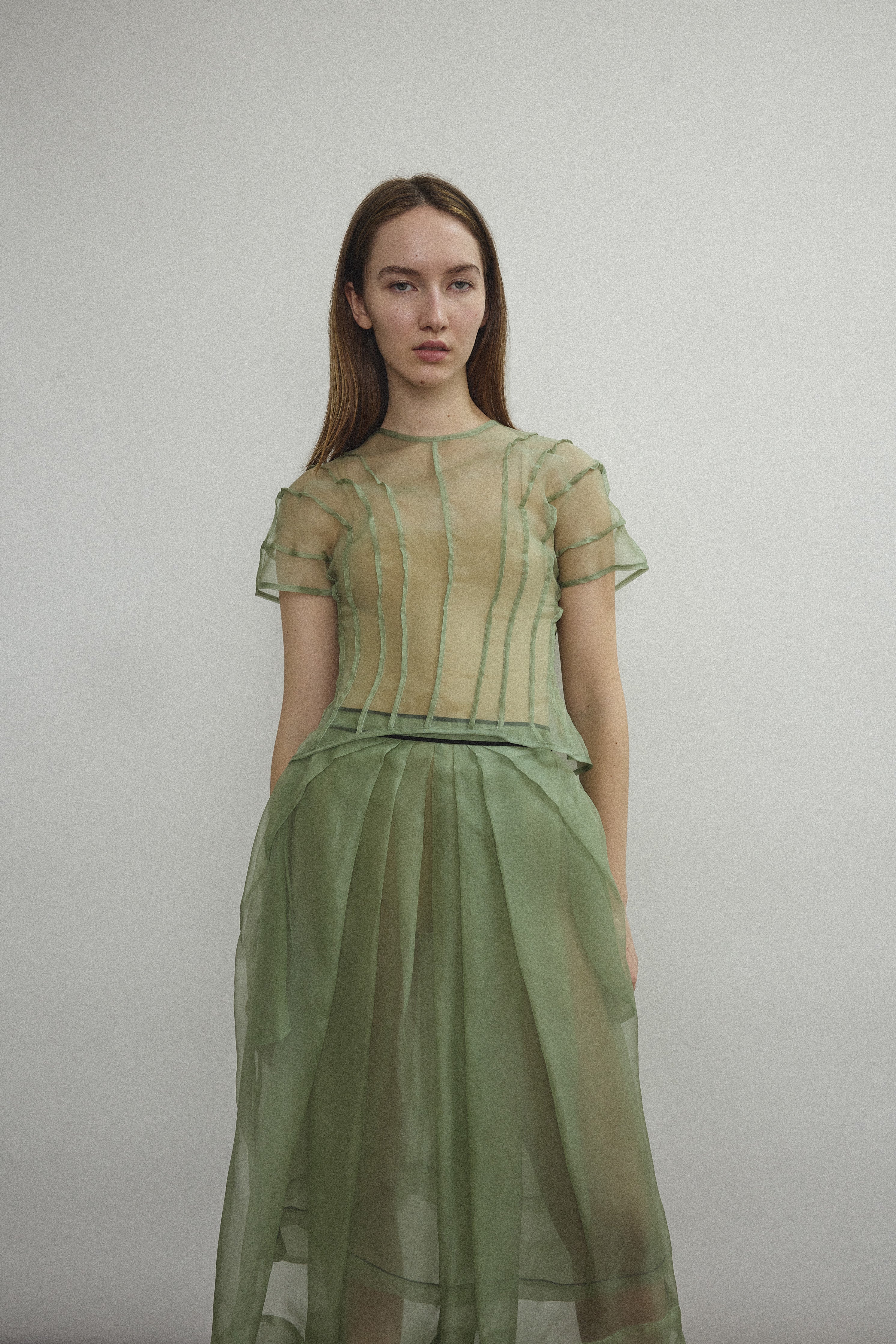 Model wearing the Kamperett Anemoia Blouse in Jade silk organza, highlighting the voluminous sculptural sleeves and elegant mock neck silhouette.