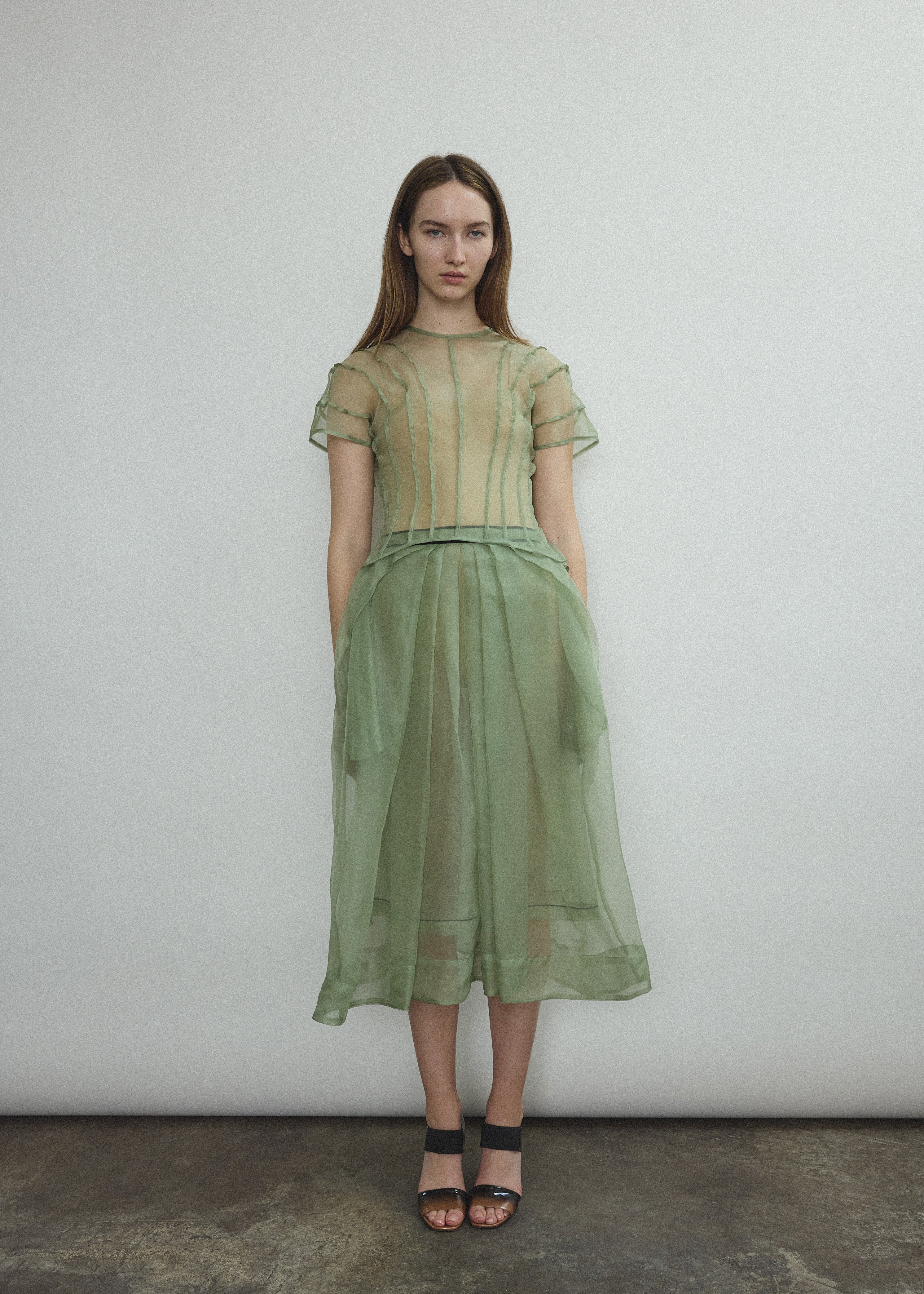 Model wearing the Kamperett Anemoia Blouse in Jade silk organza, highlighting the voluminous sculptural sleeves and elegant mock neck silhouette.