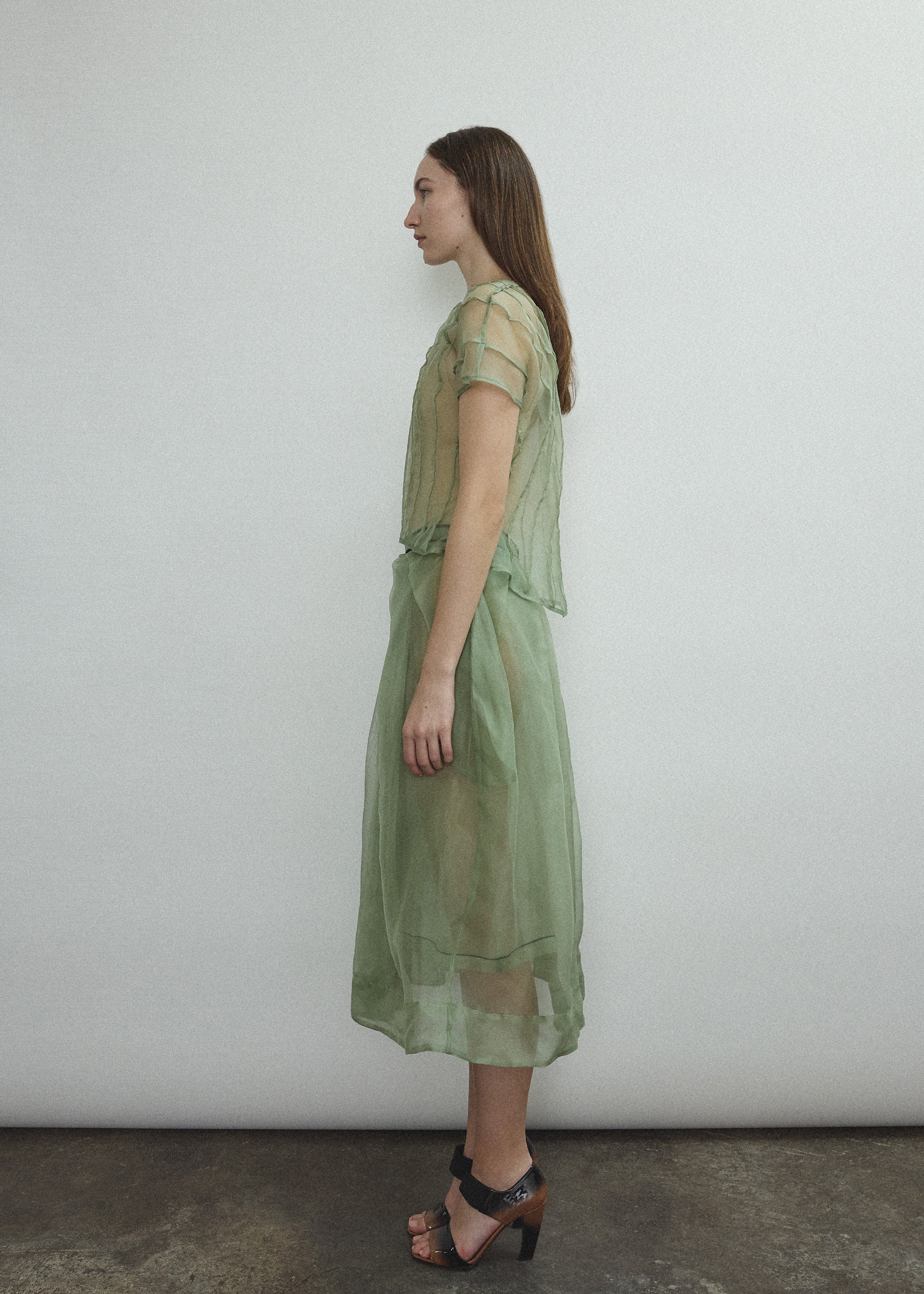 Model wearing the Kamperett Anemoia Blouse in Jade silk organza, highlighting the voluminous sculptural sleeves and elegant mock neck silhouette.