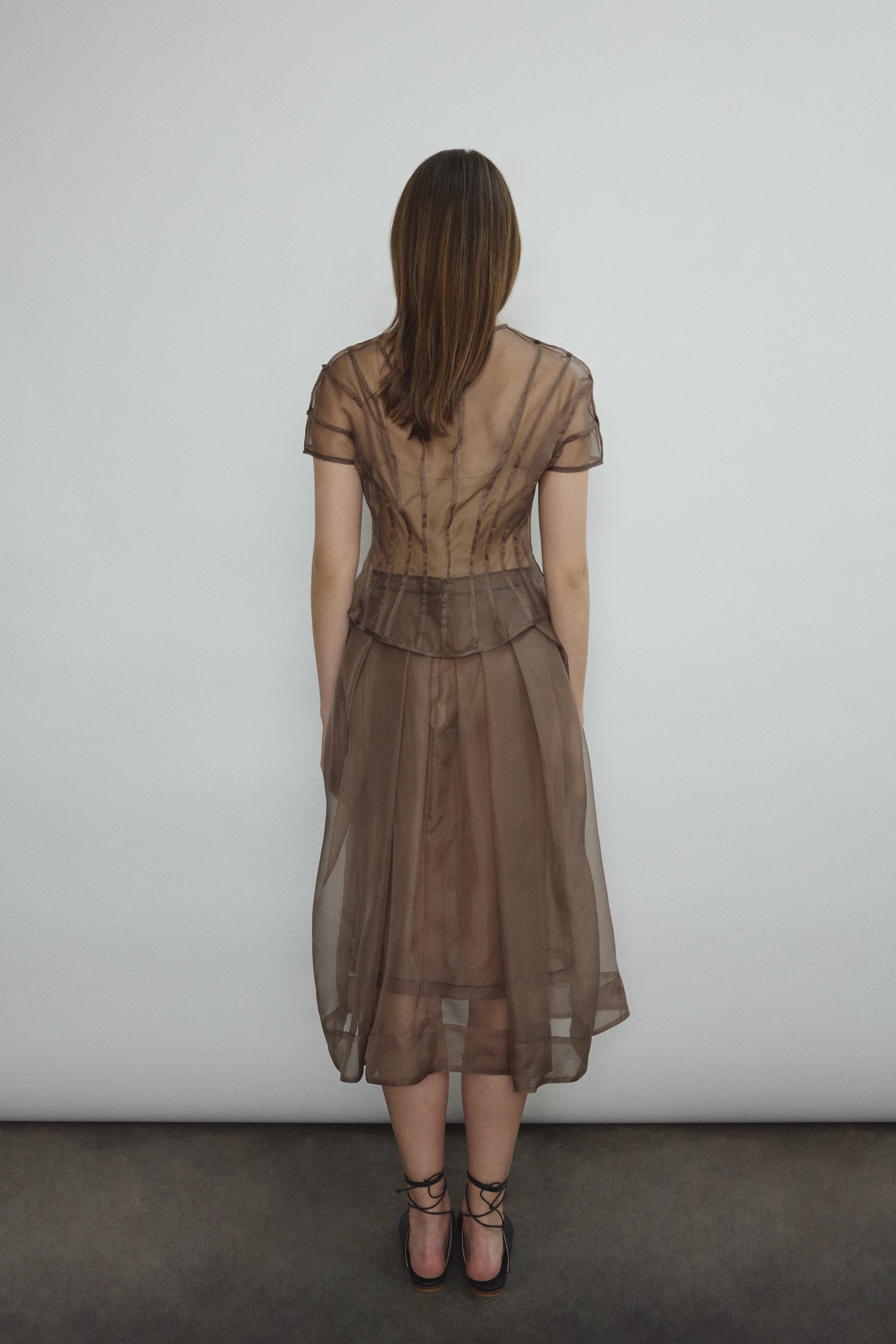 Model wearing the Kamperett Anemoia Blouse in Mushroom silk organza, highlighting the voluminous sculptural sleeves and elegant mock neck silhouette.