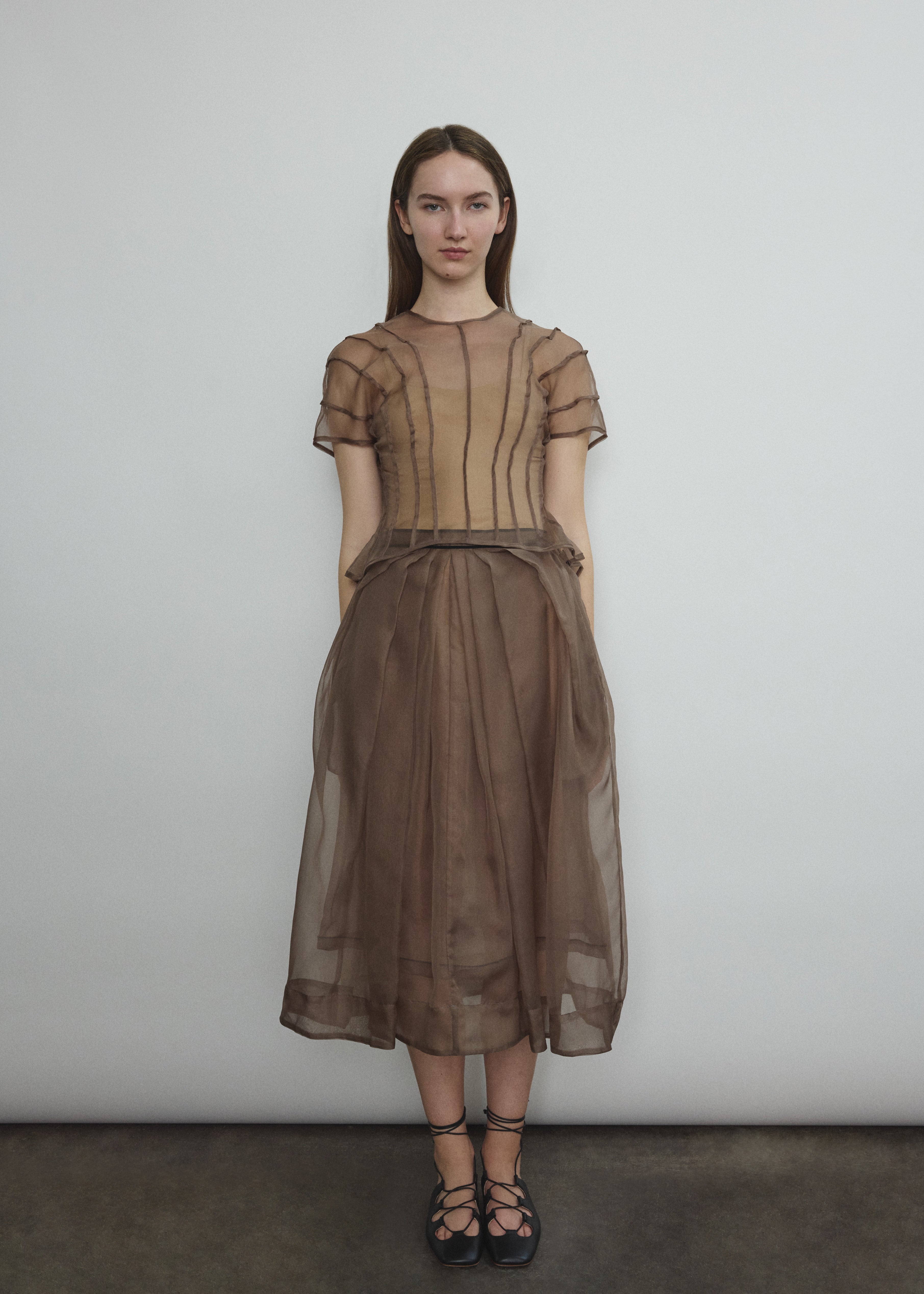 Model wearing the Kamperett Anemoia Blouse in Mushroom silk organza, highlighting the voluminous sculptural sleeves and elegant mock neck silhouette.