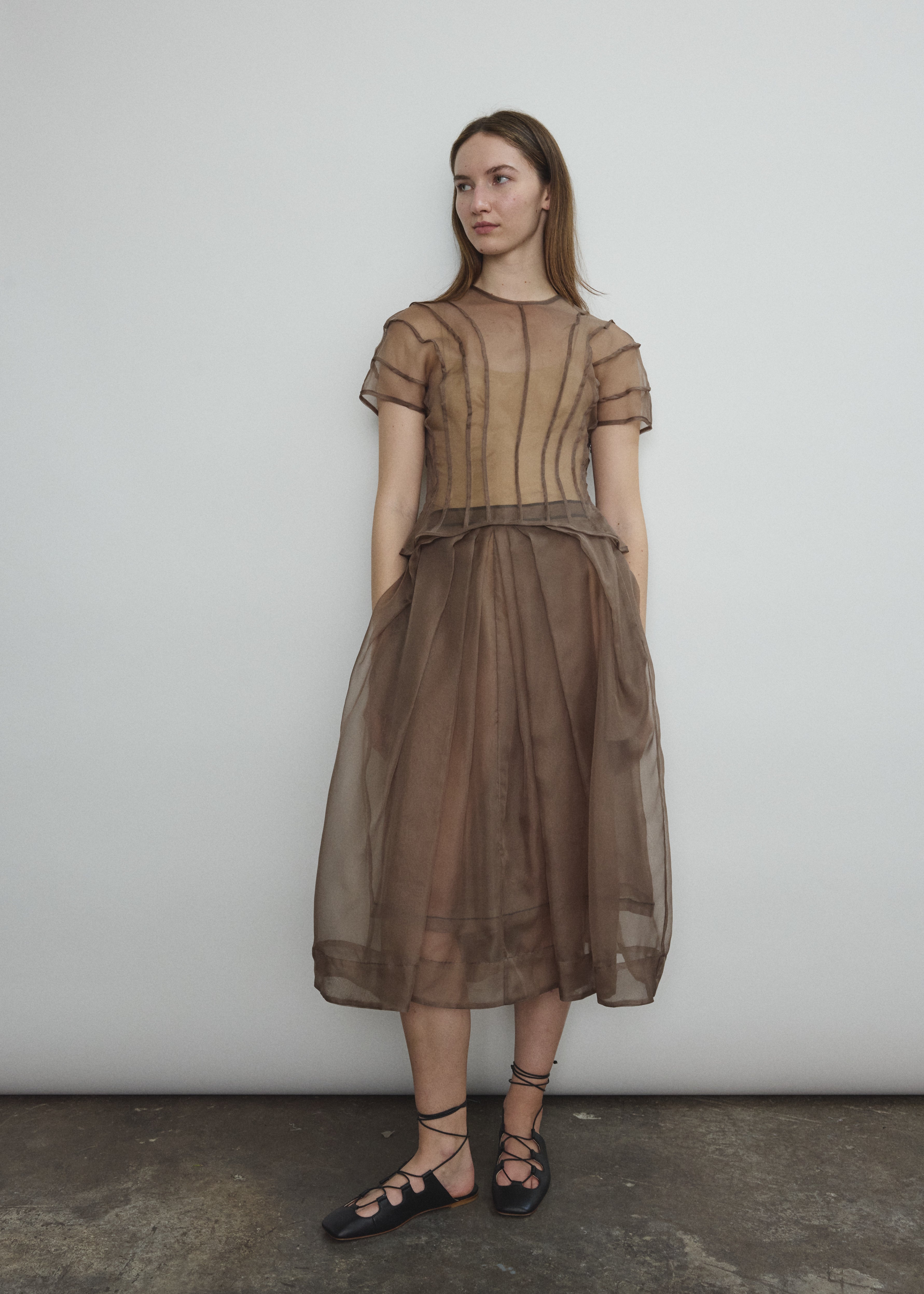 Model wearing the Kamperett Anemoia Blouse in Mushroom silk organza, highlighting the voluminous sculptural sleeves and elegant mock neck silhouette.