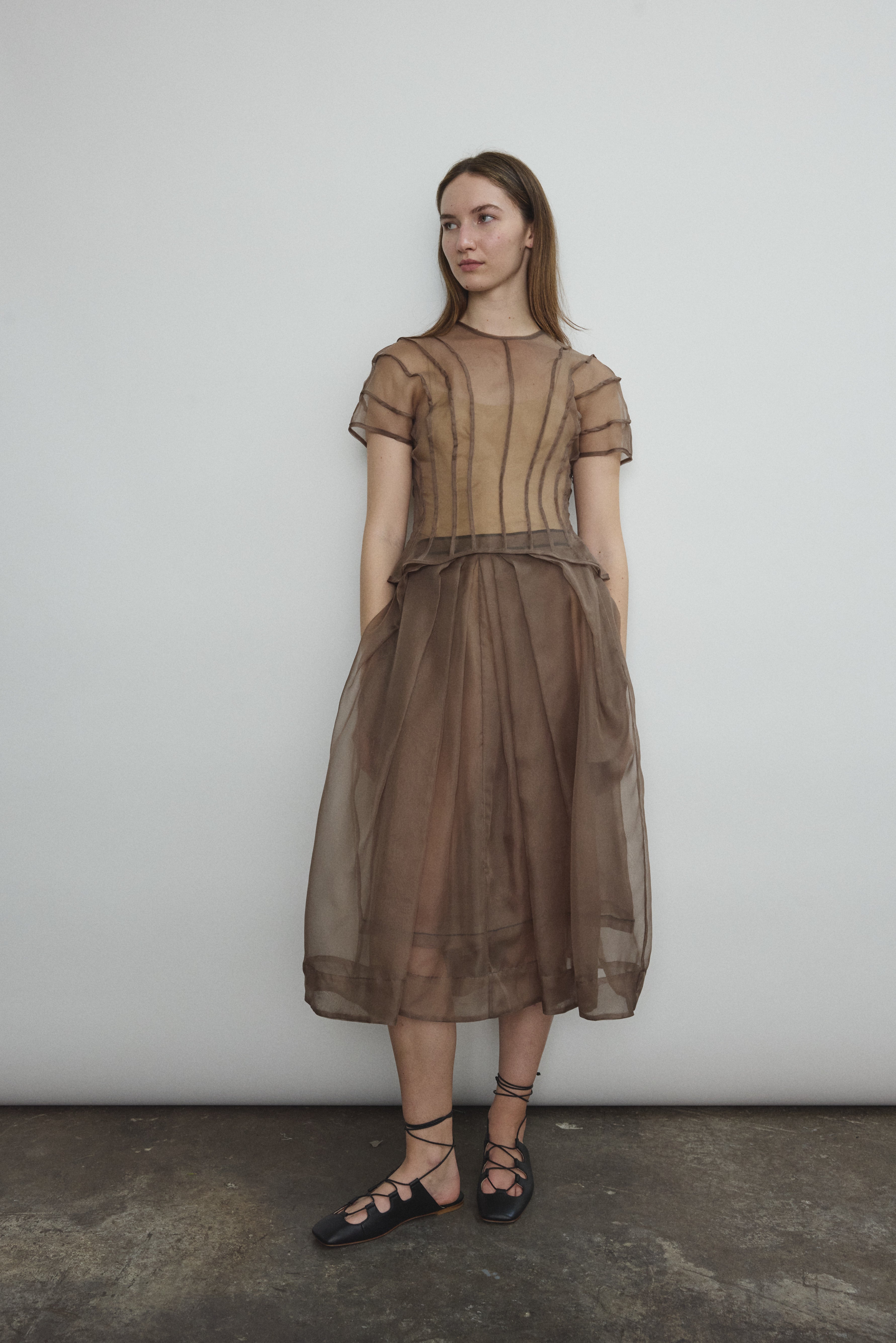 Model wearing the Kamperett Anemoia Blouse in Mushroom silk organza, highlighting the voluminous sculptural sleeves and elegant mock neck silhouette.
