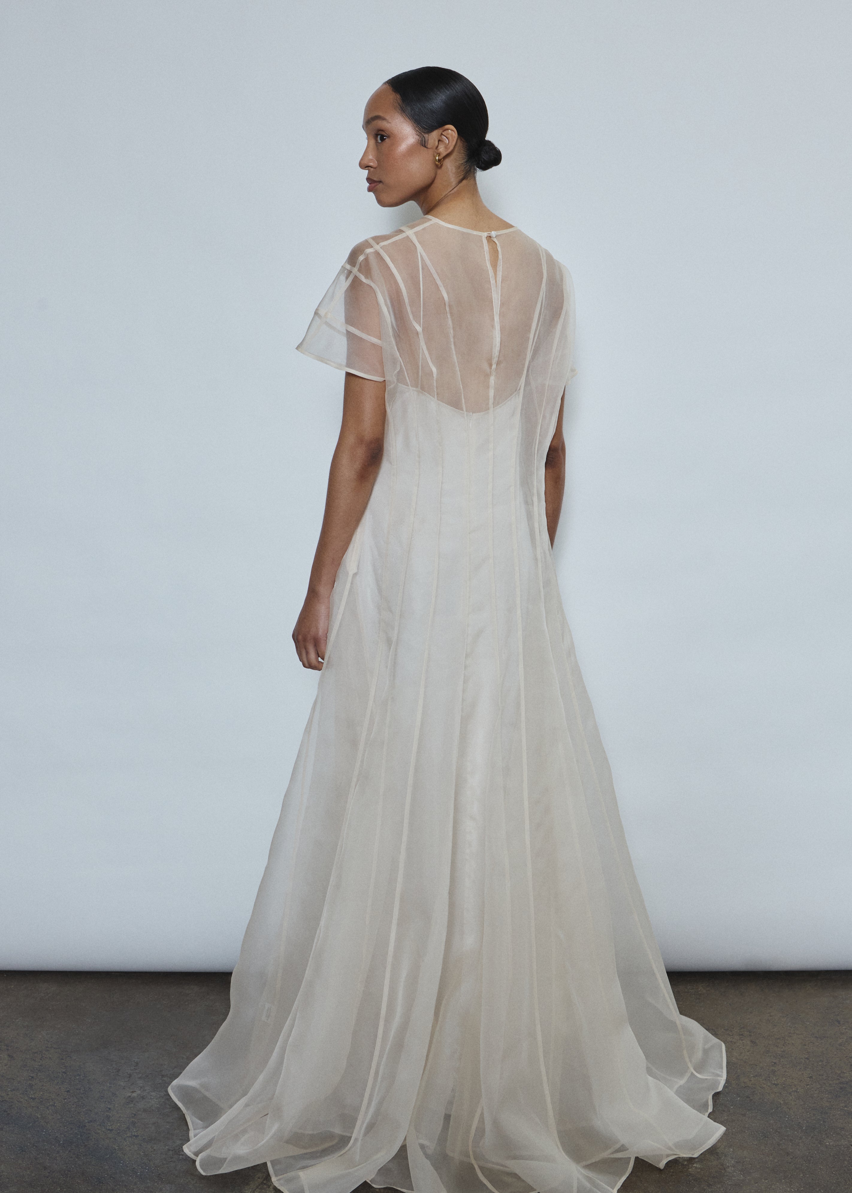 Model wearing the voluminous Kamperett Anemoia Gown in Ivory silk organza, featuring architectural French seams and a graceful floor-length silhouette.