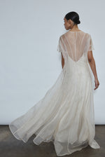 Rear view of ivory Anemoia Gown showing black silk button closure at center back neck. Architectural straight-cut silhouette in French lace organza.
