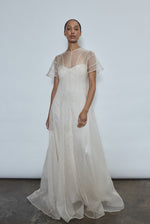 Model wearing the voluminous Kamperett Anemoia Gown in Ivory silk organza, featuring architectural French seams and a graceful floor-length silhouette.