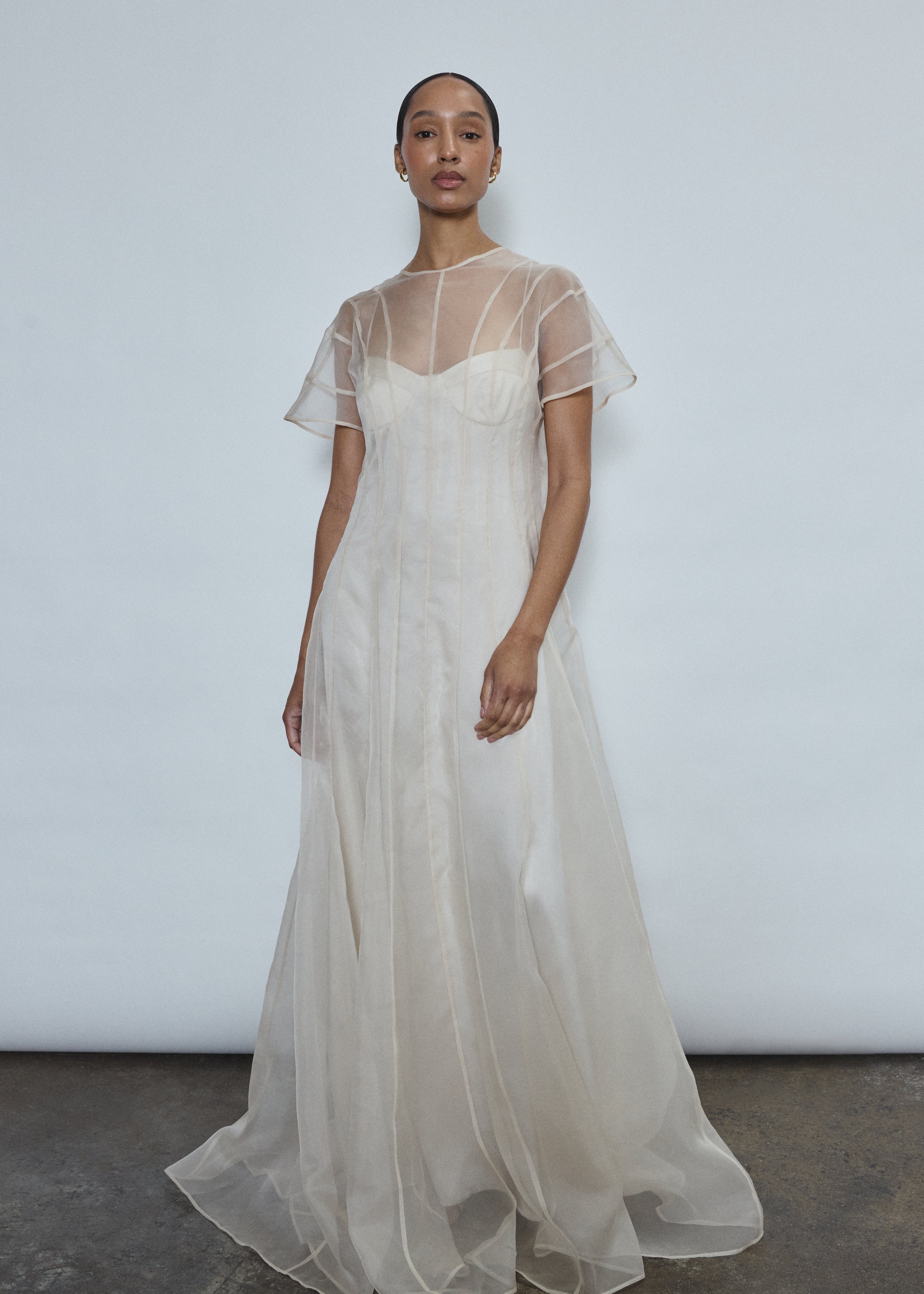 Model wearing the voluminous Kamperett Anemoia Gown in Ivory silk organza, featuring architectural French seams and a graceful floor-length silhouette.