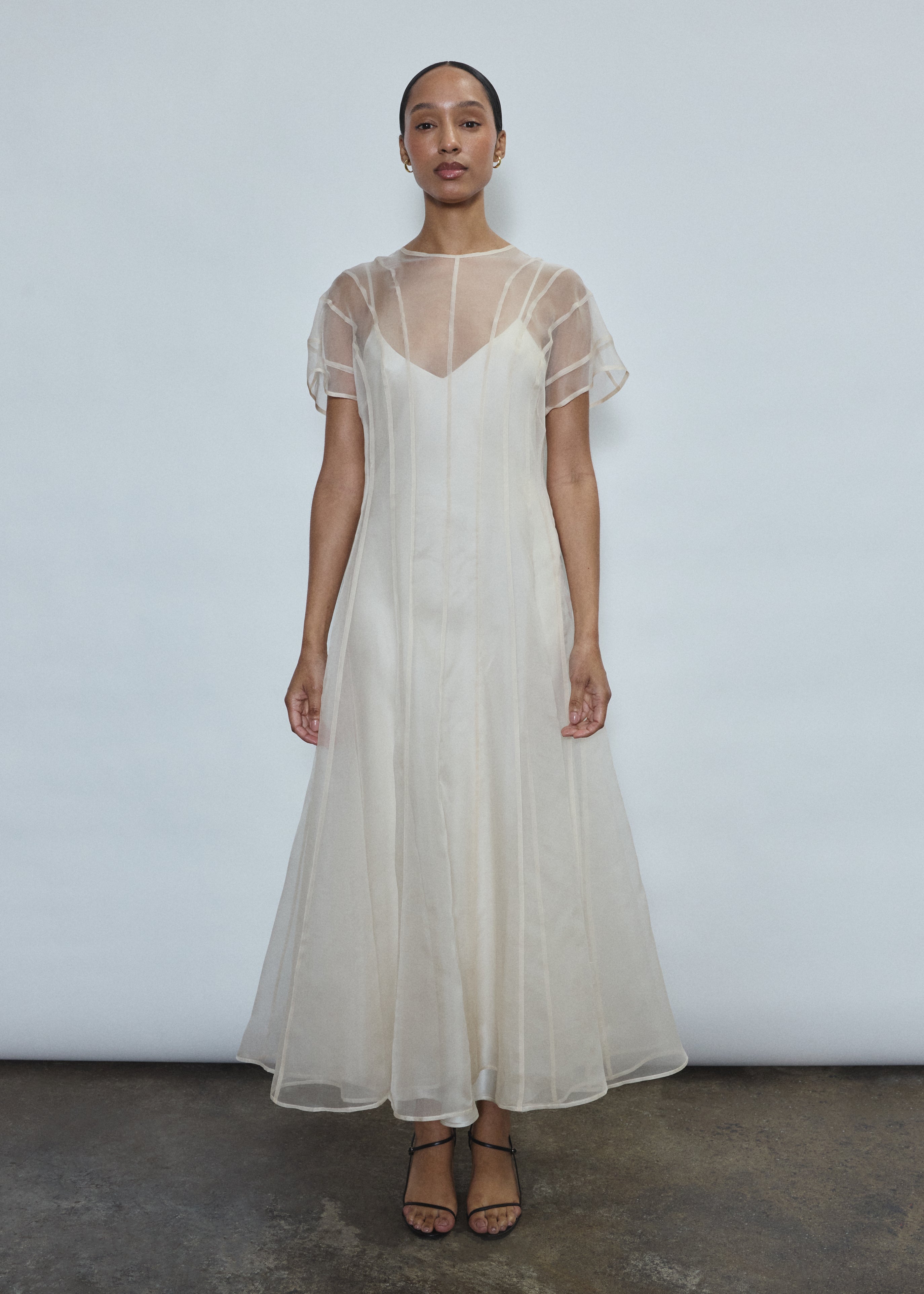 Model wearing the voluminous Kamperett Anemoia Midi dress in Ivory silk organza, highlighting the architectural French seams and graceful midi-length silhouette.