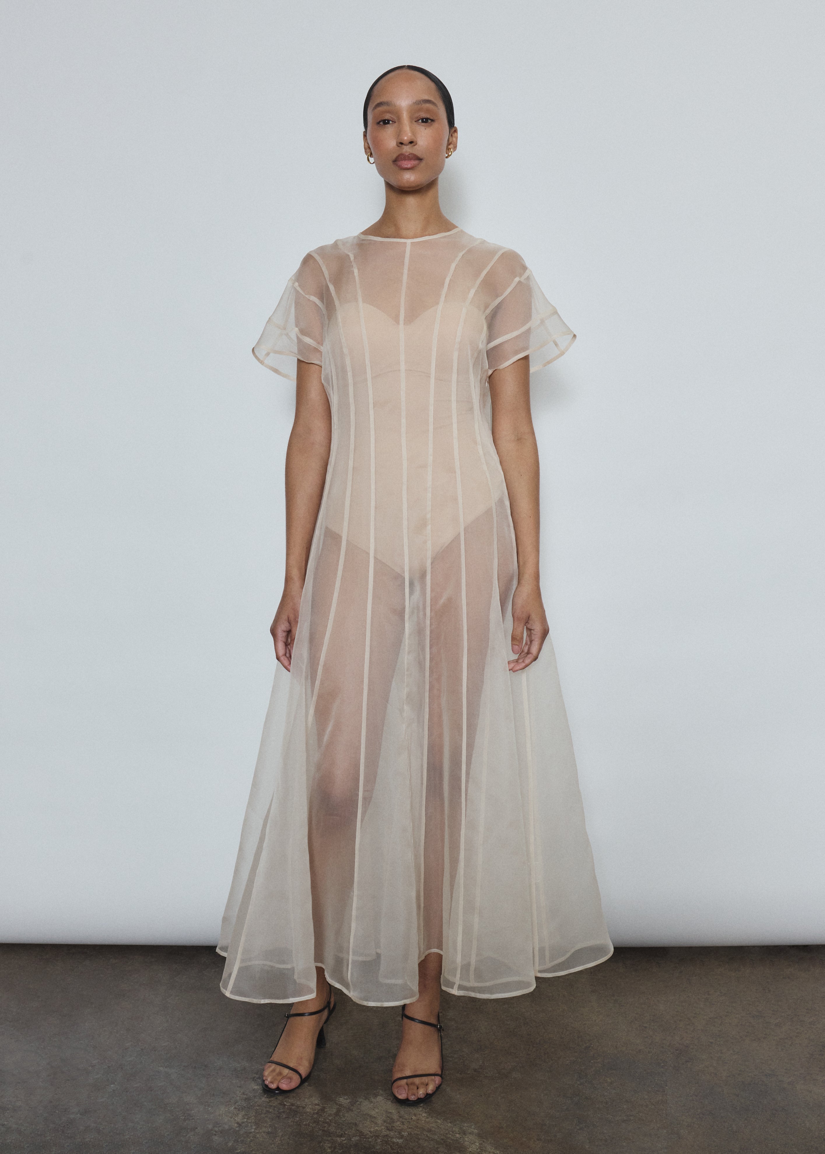 Model wearing the voluminous Kamperett Anemoia Midi dress in Ivory silk organza, highlighting the architectural French seams and graceful midi-length silhouette.