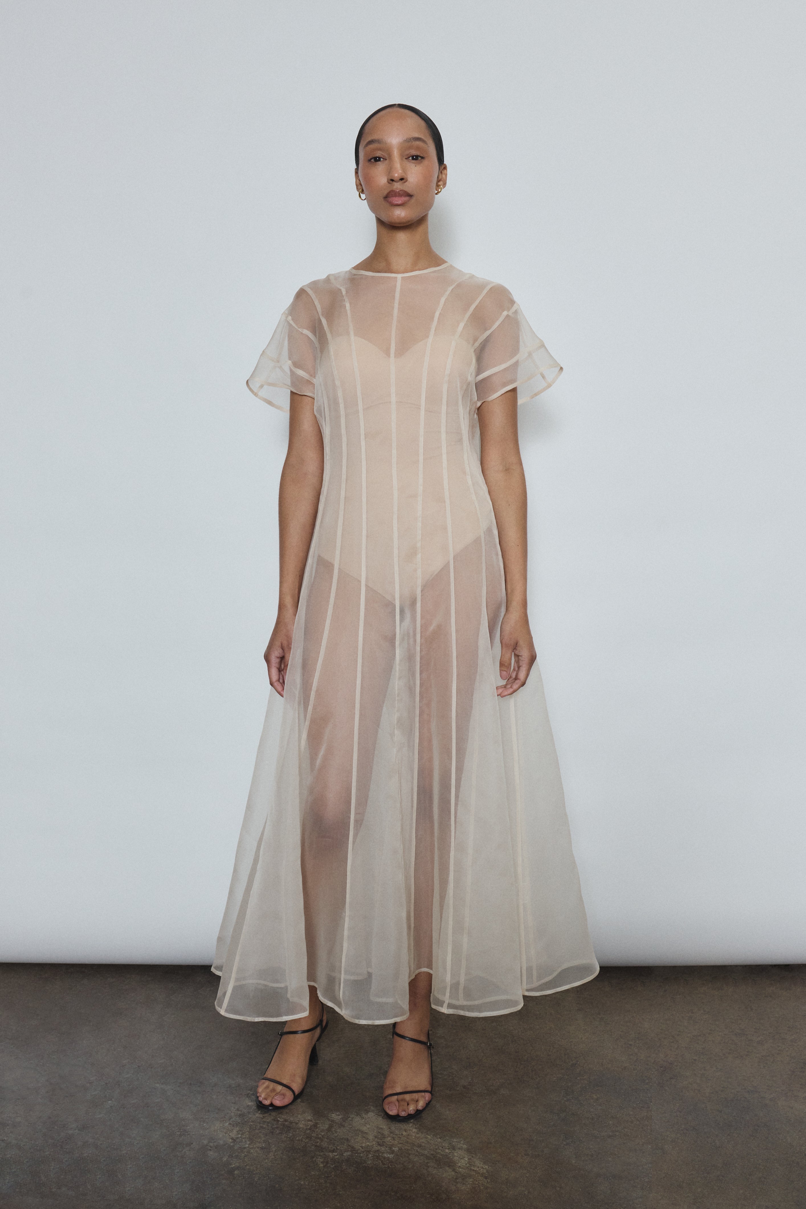 Model wearing the voluminous Kamperett Anemoia Midi dress in Ivory silk organza, highlighting the architectural French seams and graceful midi-length silhouette.