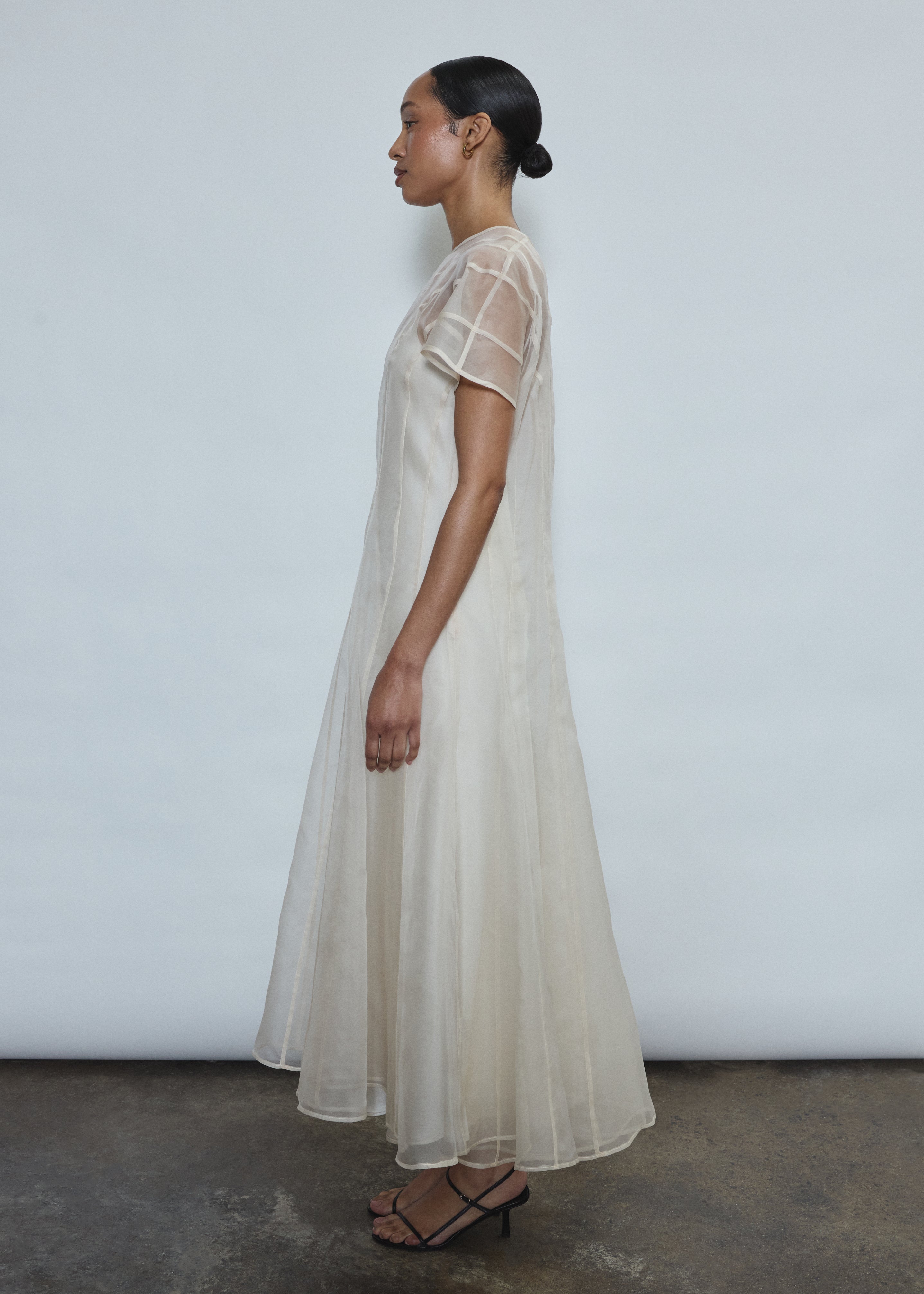 Model wearing the voluminous Kamperett Anemoia Midi dress in Ivory silk organza, highlighting the architectural French seams and graceful midi-length silhouette.