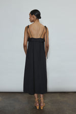 Model wearing the black Kamperett Anis Dress in black. An a-line midi dress constructed from 100% mid weight Japanese cotton. 