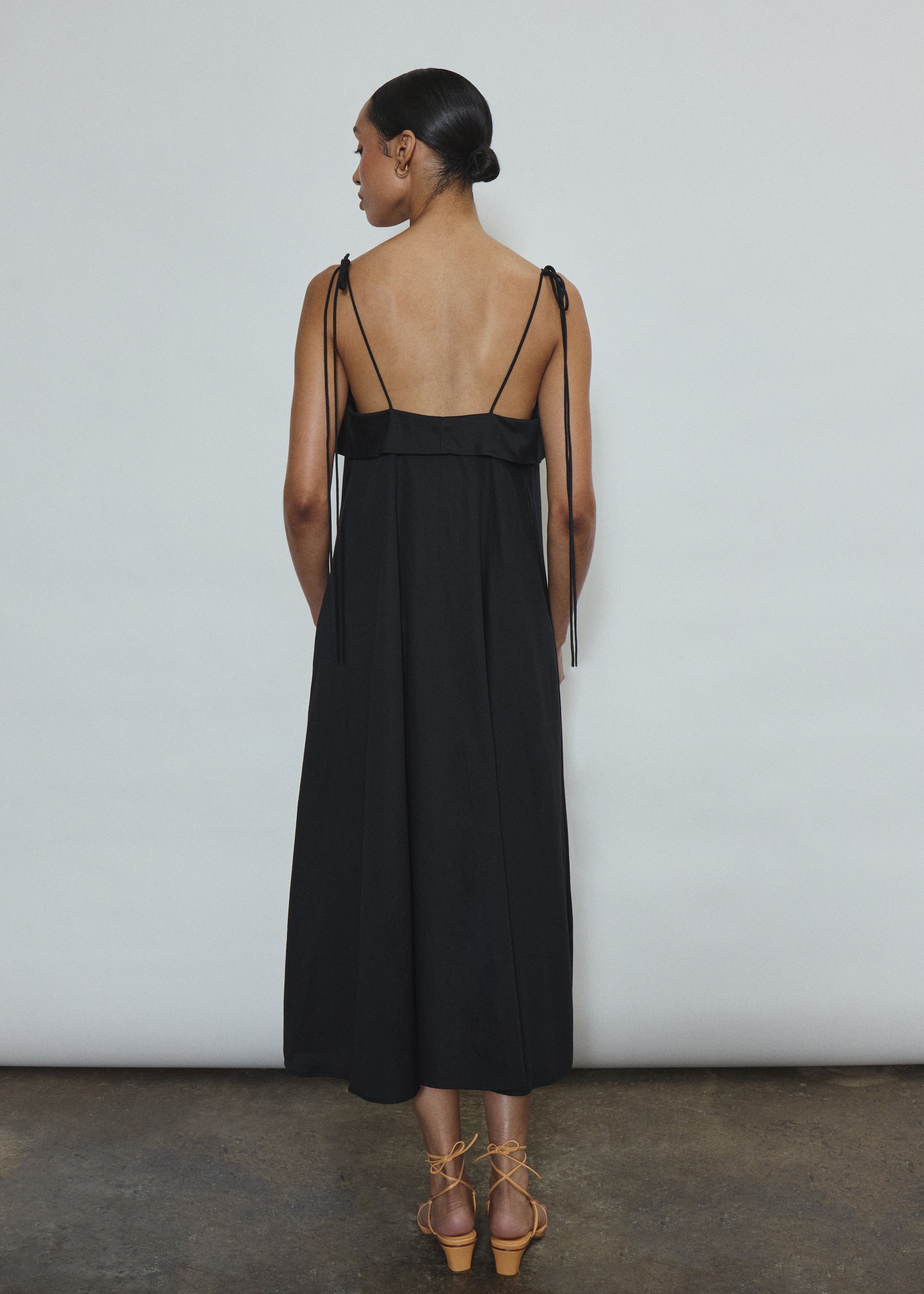 Model wearing the black Kamperett Anis Dress in black. An a-line midi dress constructed from 100% mid weight Japanese cotton. 