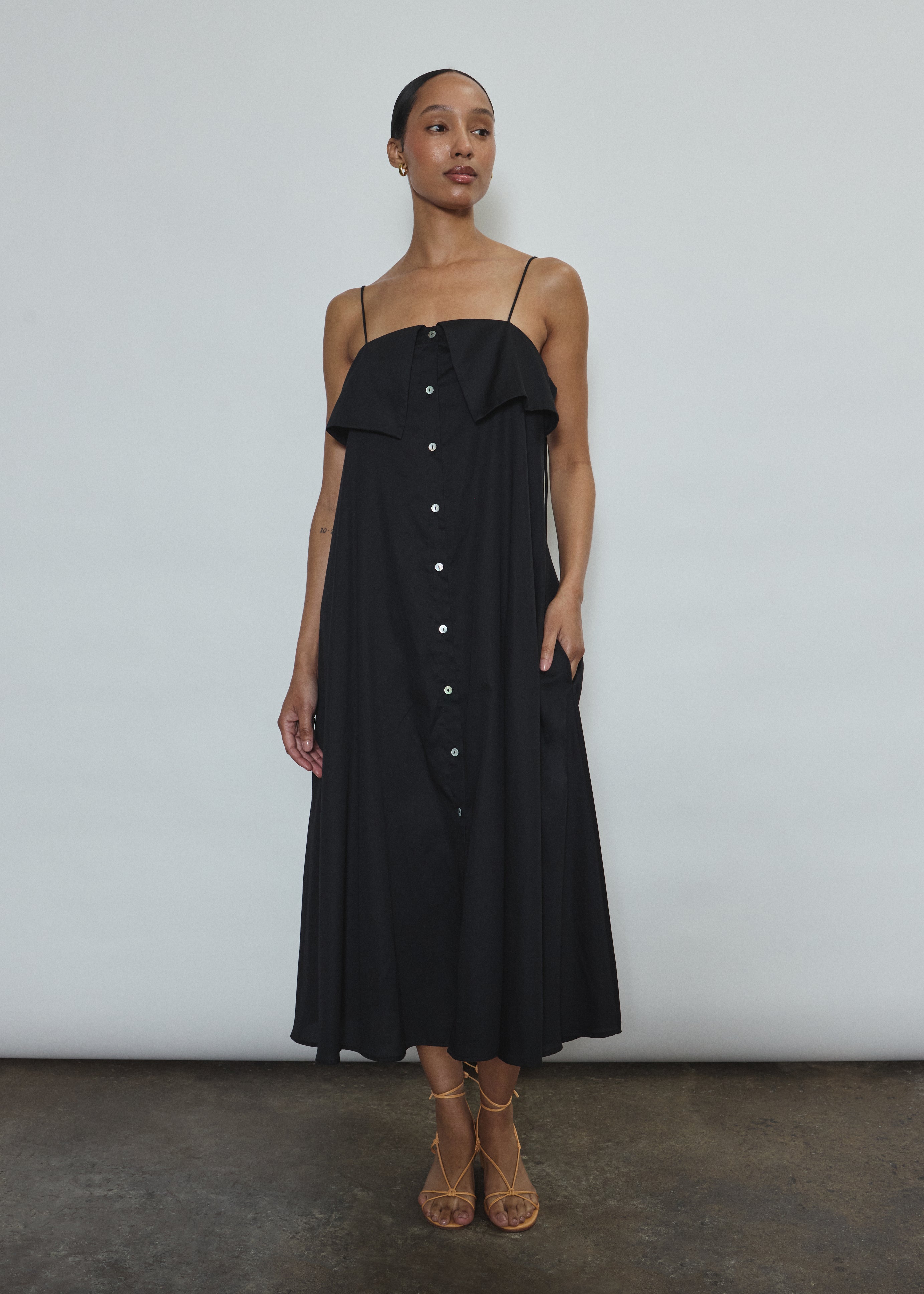 Model wearing the black Kamperett Anis Dress in black. An a-line midi dress constructed from 100% mid weight Japanese cotton. 