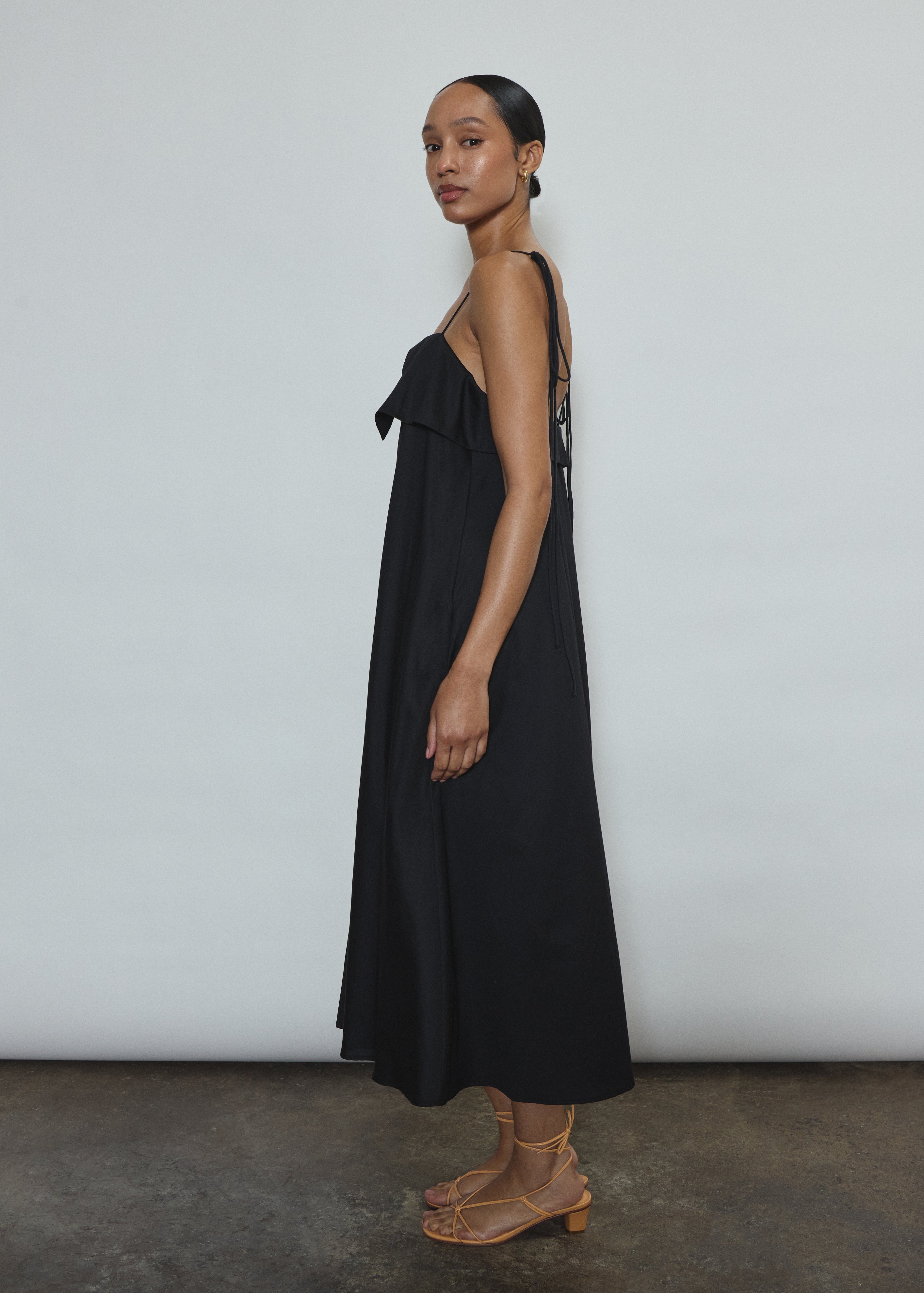 Model wearing the black Kamperett Anis Dress in black. An a-line midi dress constructed from 100% mid weight Japanese cotton. 
