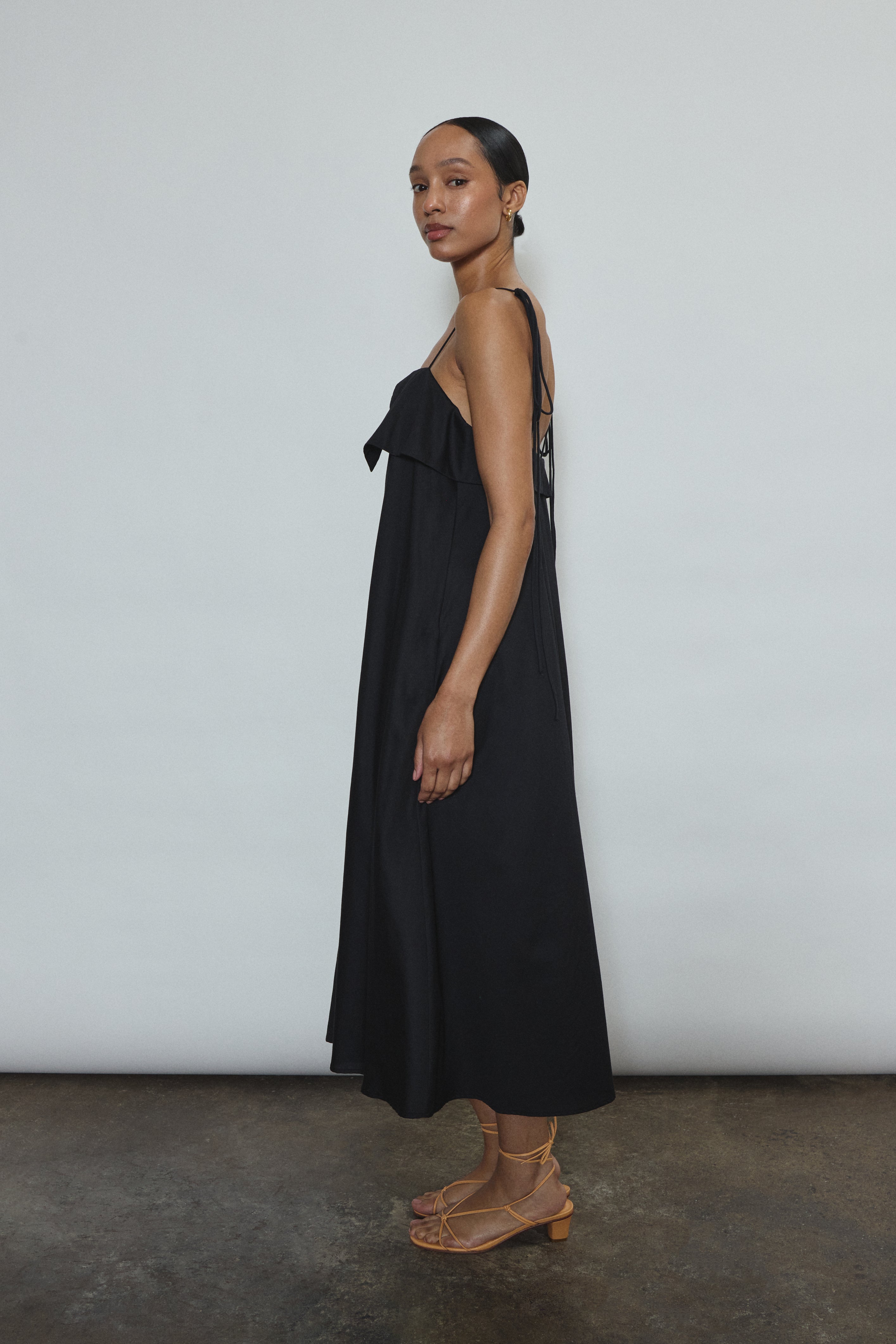 Model wearing the black Kamperett Anis Dress in black. An a-line midi dress constructed from 100% mid weight Japanese cotton. 