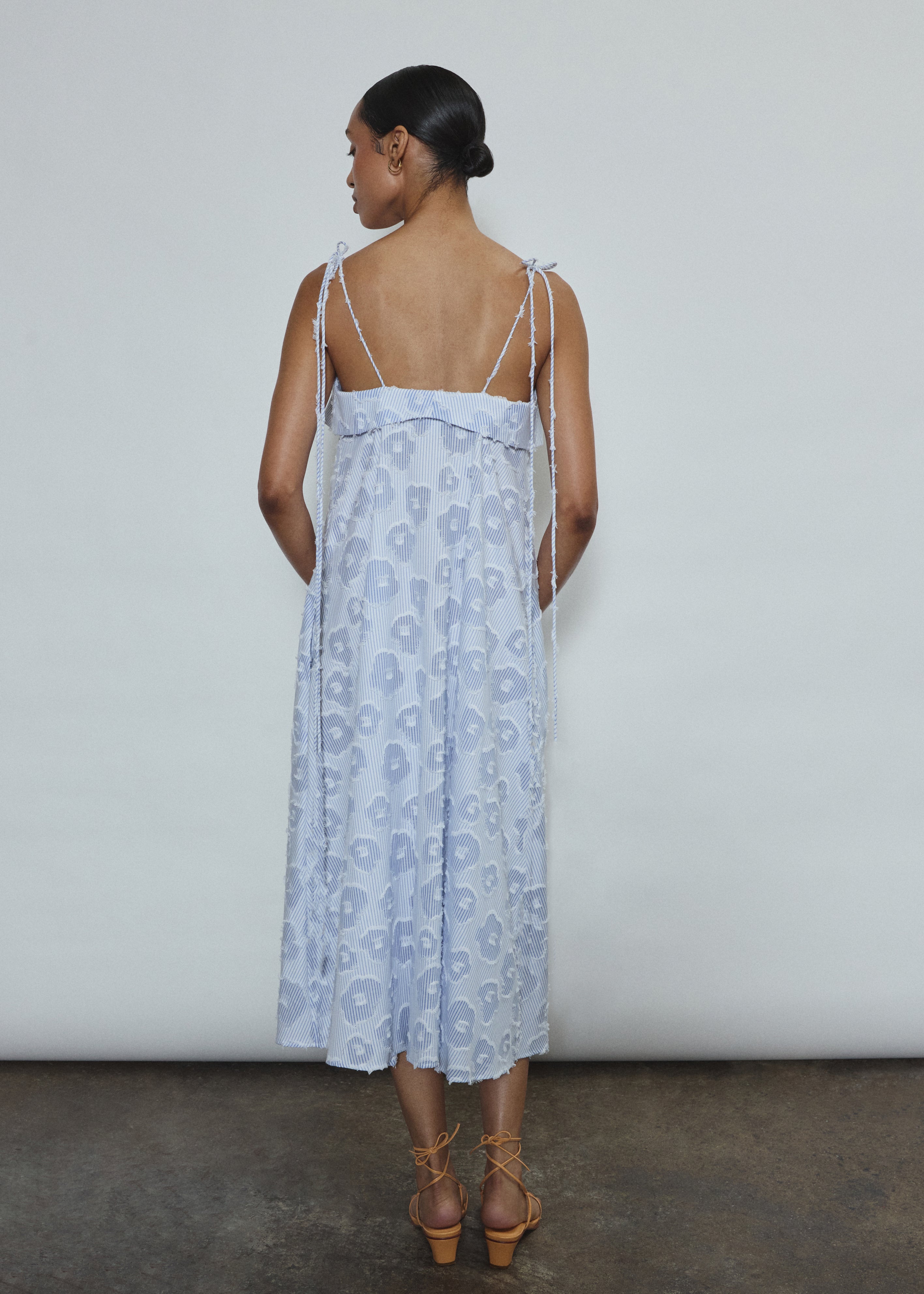 Model wearing the black Kamperett Anis Dress in blue floral. An a-line midi dress constructed from 100% mid weight Japanese cotton. 