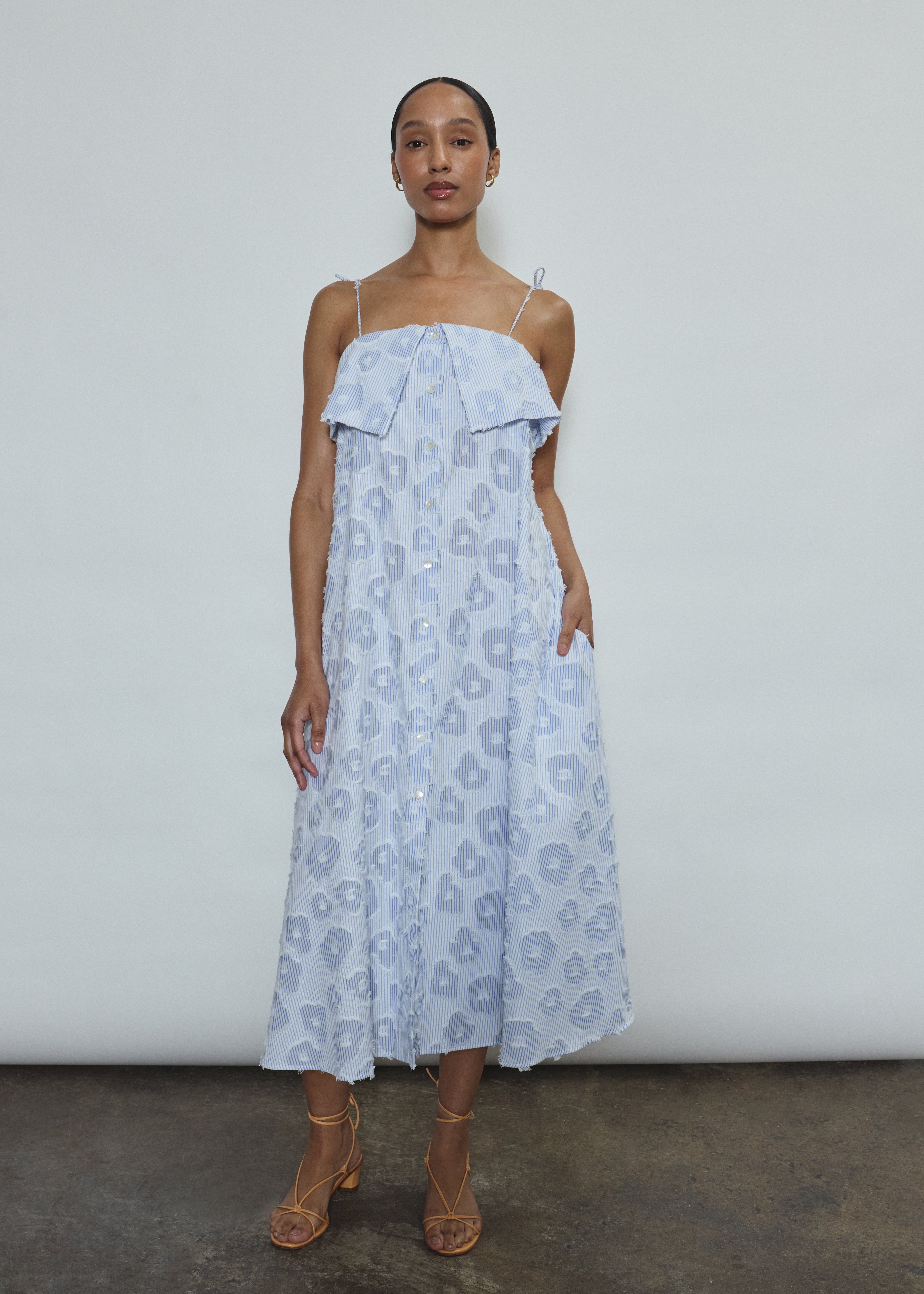 Model wearing the black Kamperett Anis Dress in blue floral. An a-line midi dress constructed from 100% mid weight Japanese cotton. 