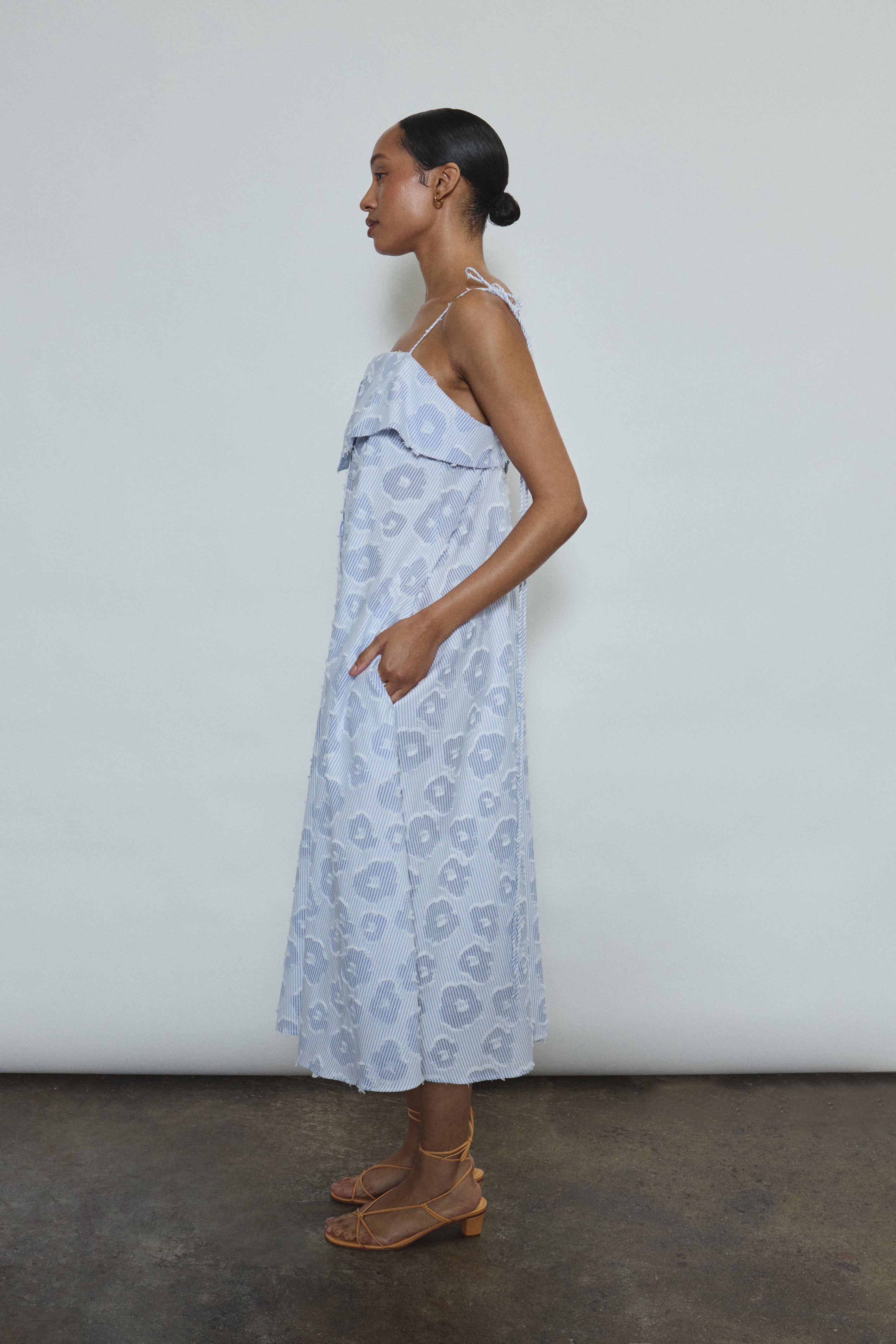 Model wearing the black Kamperett Anis Dress in blue floral. An a-line midi dress constructed from 100% mid weight Japanese cotton. 