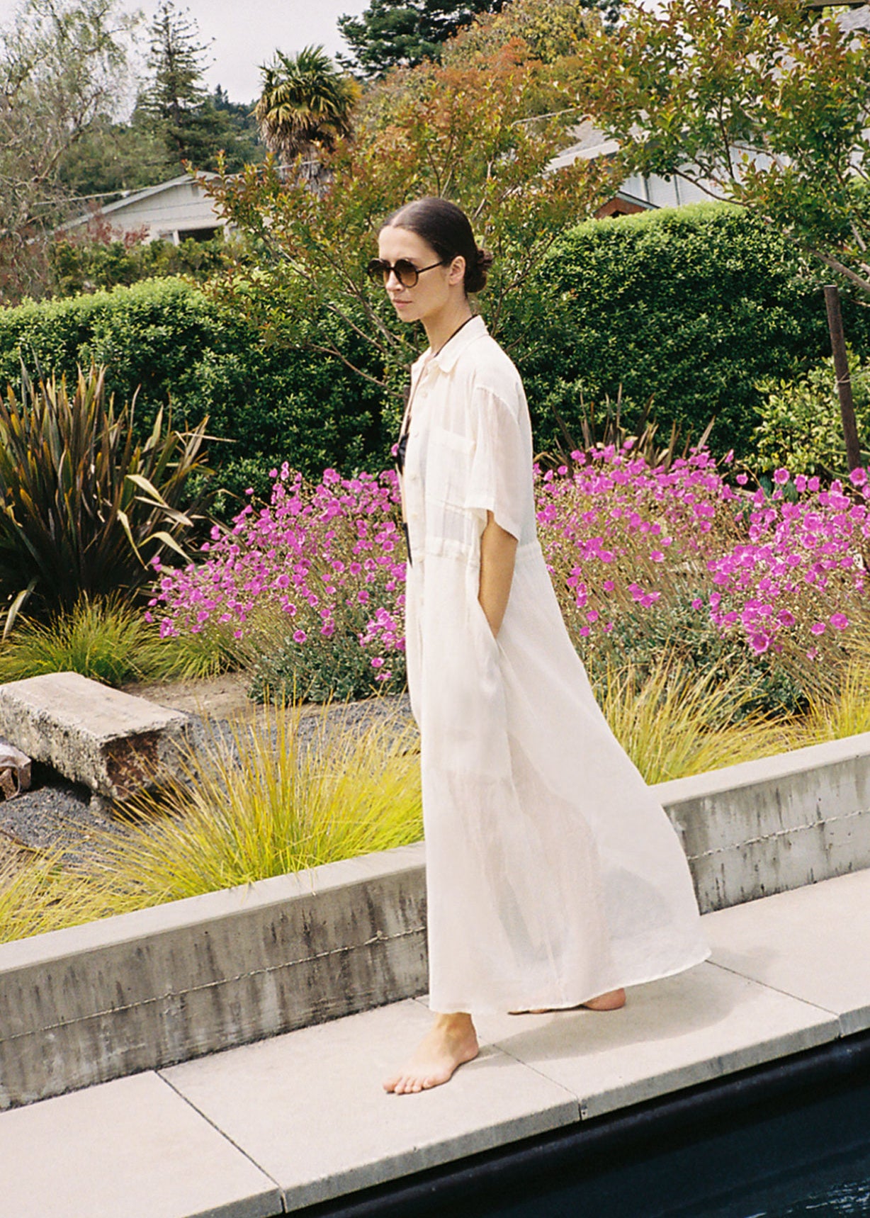 Front view of a model wearing the white semi-sheer Japanese cotton voile Kamperett Antoine Shirt Dress with drawstring waist.