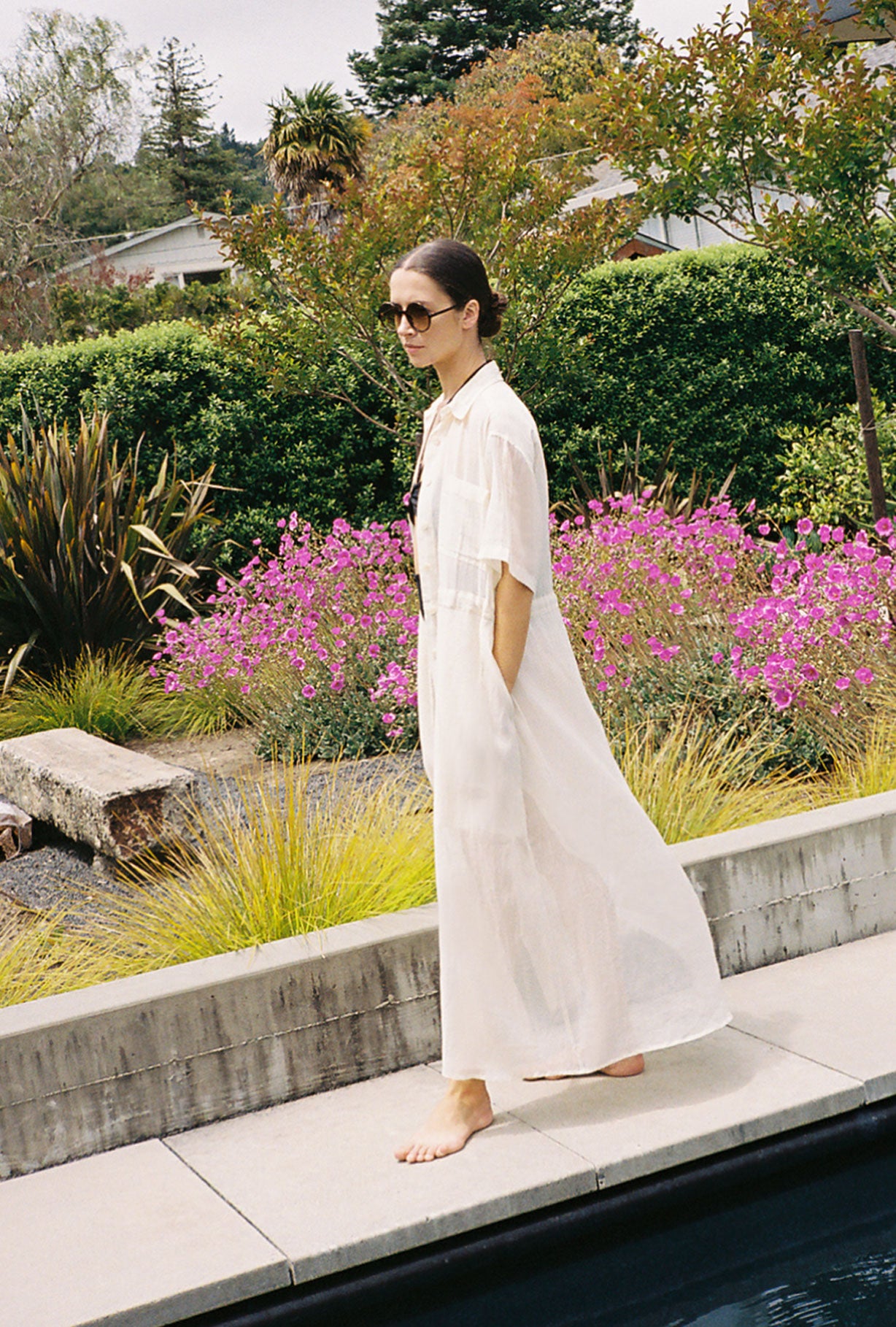 Front view of a model wearing the white semi-sheer Japanese cotton voile Kamperett Antoine Shirt Dress with drawstring waist.