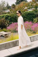 Front view of a model wearing the white semi-sheer Japanese cotton voile Kamperett Antoine Shirt Dress with drawstring waist.