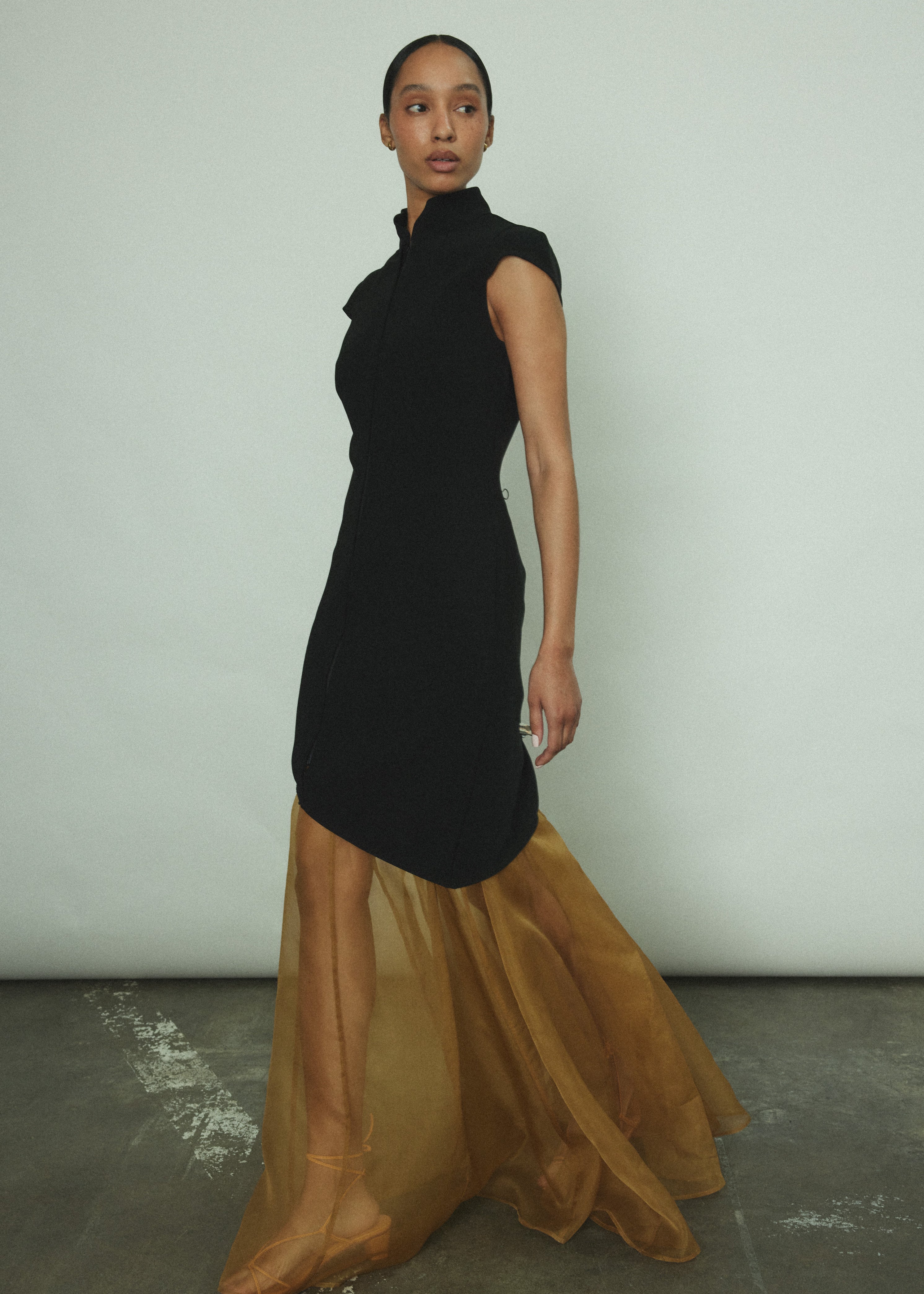 Side view of the black wool flannel Kamperett Astrid Vest showing the asymmetric hemline.